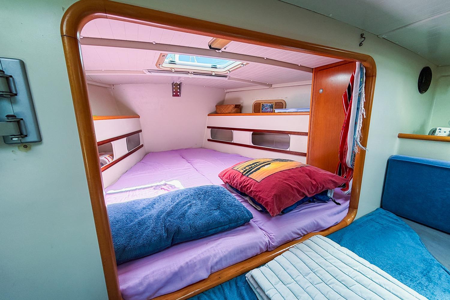 Cozy cabin interior of 2006 RM Yachts 1050 with colorful bedding and skylight.