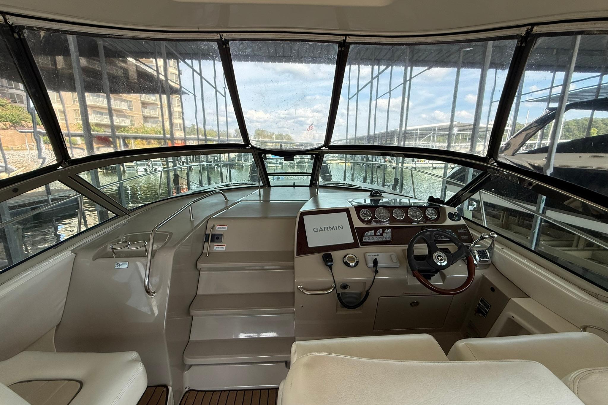 2009 Sea Ray 350 Sundancer helm with Garmin navigation, docked in a marina.