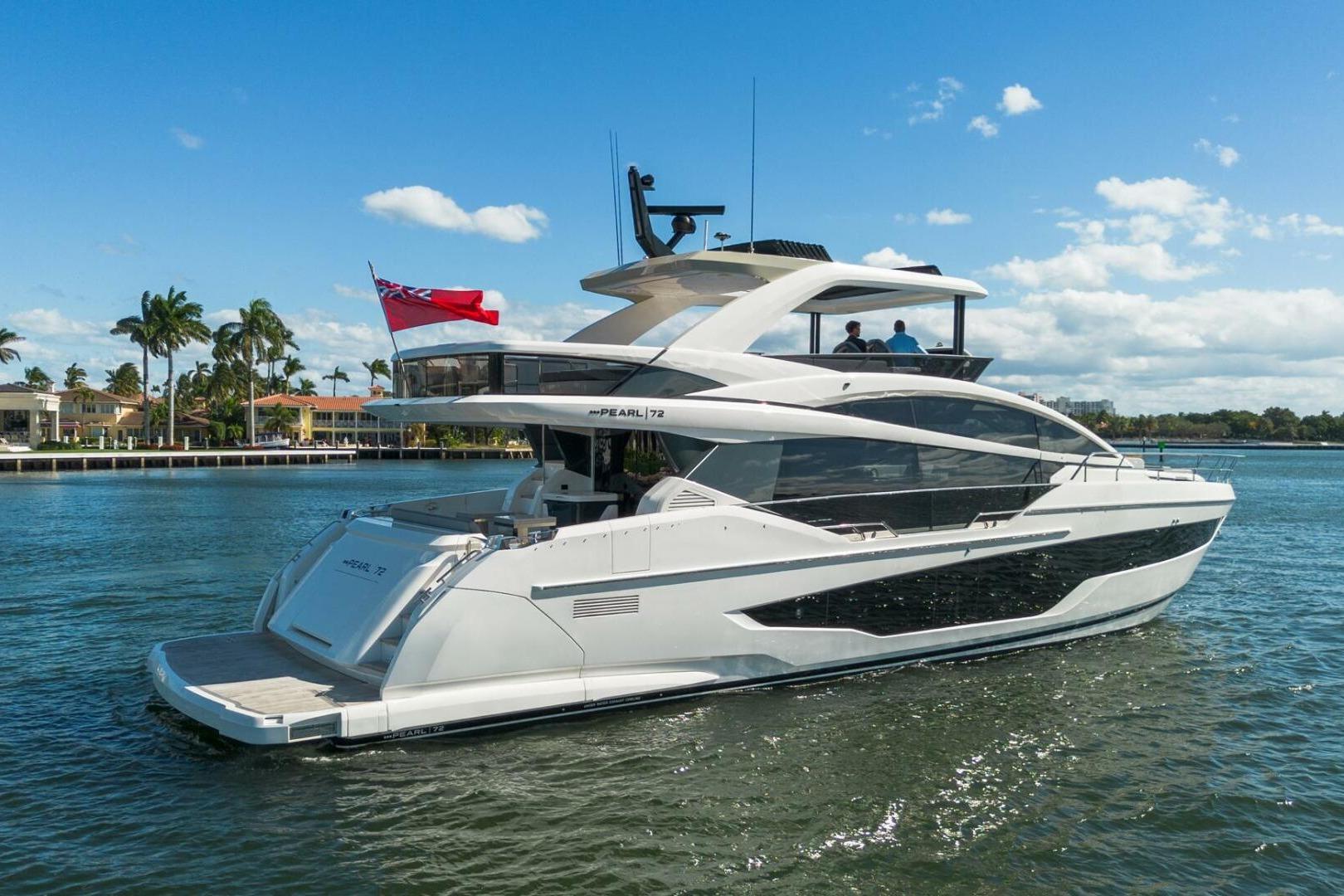 Luxurious 2023 Pearl 72 yacht cruising on a sunny day with palm trees in the background.