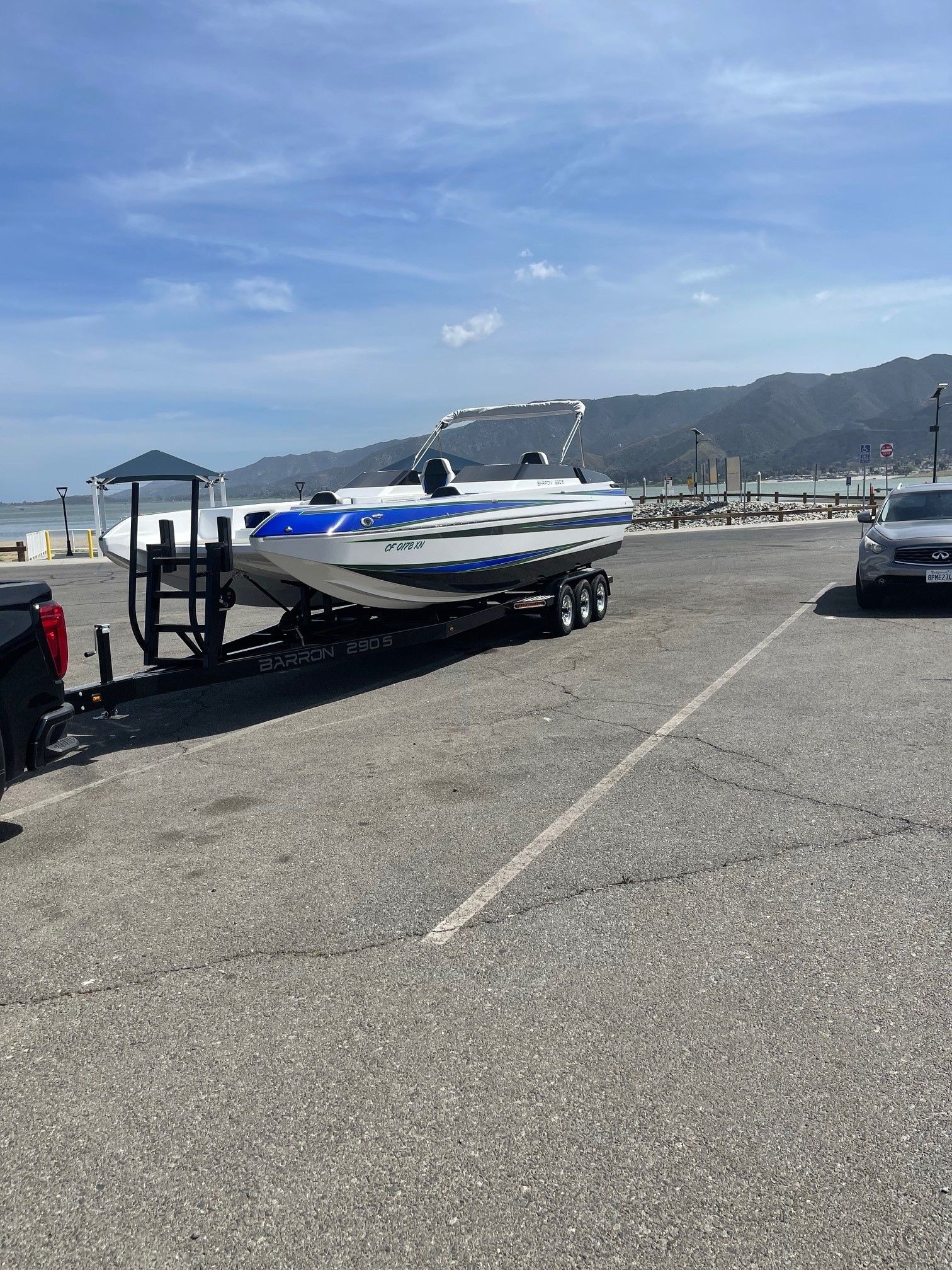 Custom Barron 290s boat on trailer, 2021 model, parked at harbor.
