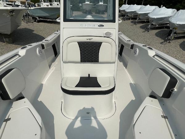 2025 Tidewater 232 CC Adventure boat interior with seating and console, displayed outdoors.