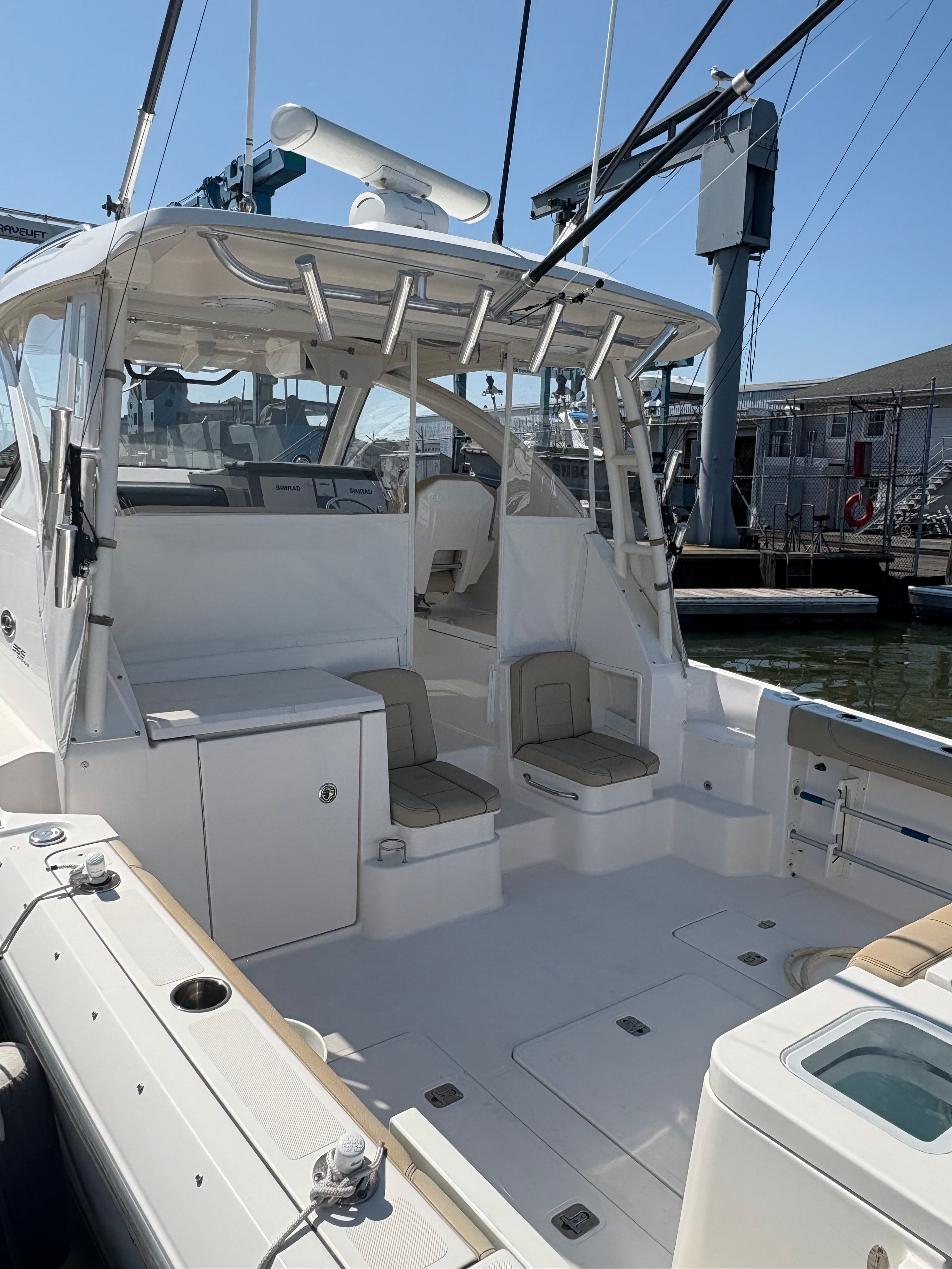2017 Pursuit OS 355 Offshore boat interior with seating and storage, docked at marina.