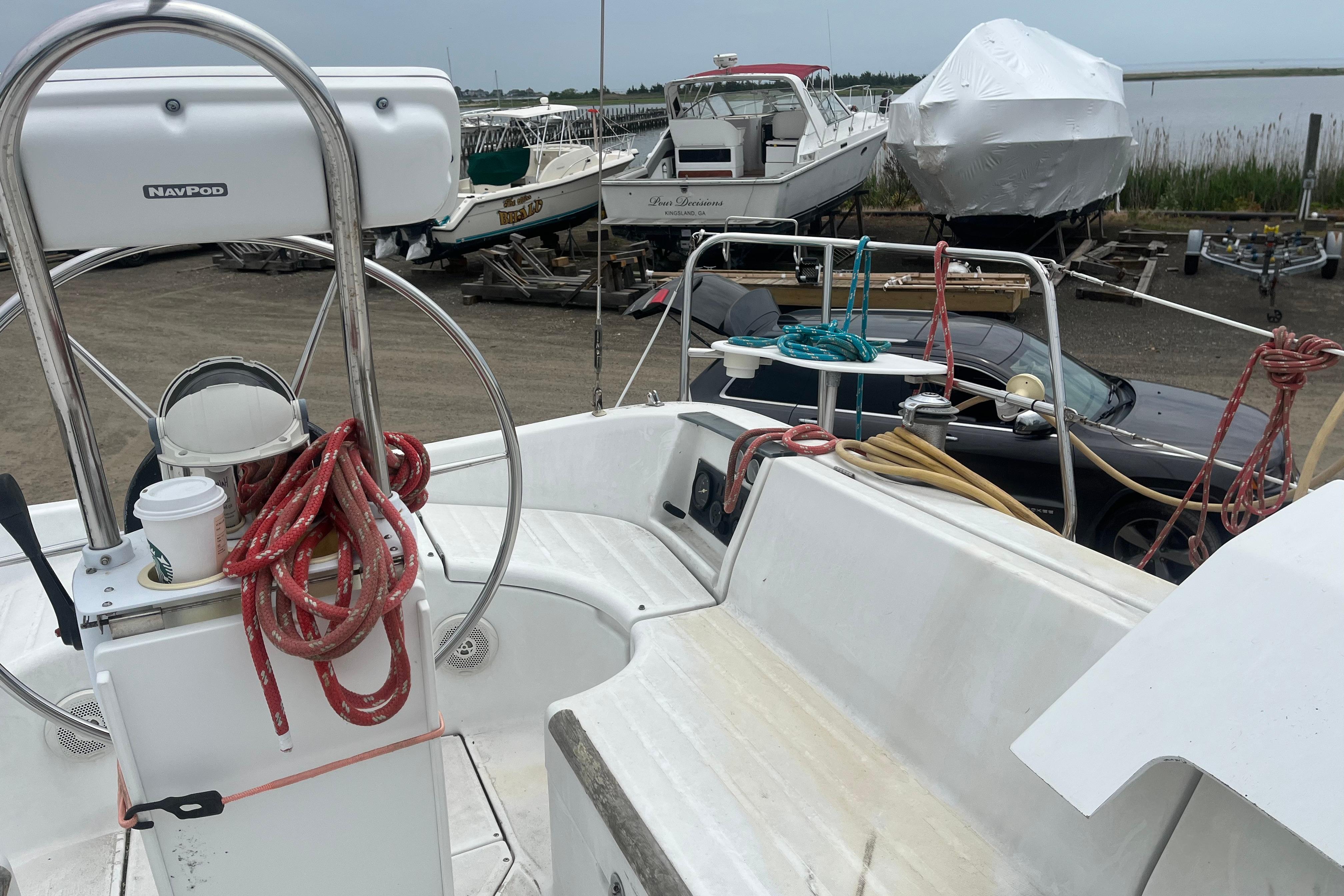 Cockpit of a 1999 Benneteau 321 Oceanis sailboat with ropes and steering wheel.