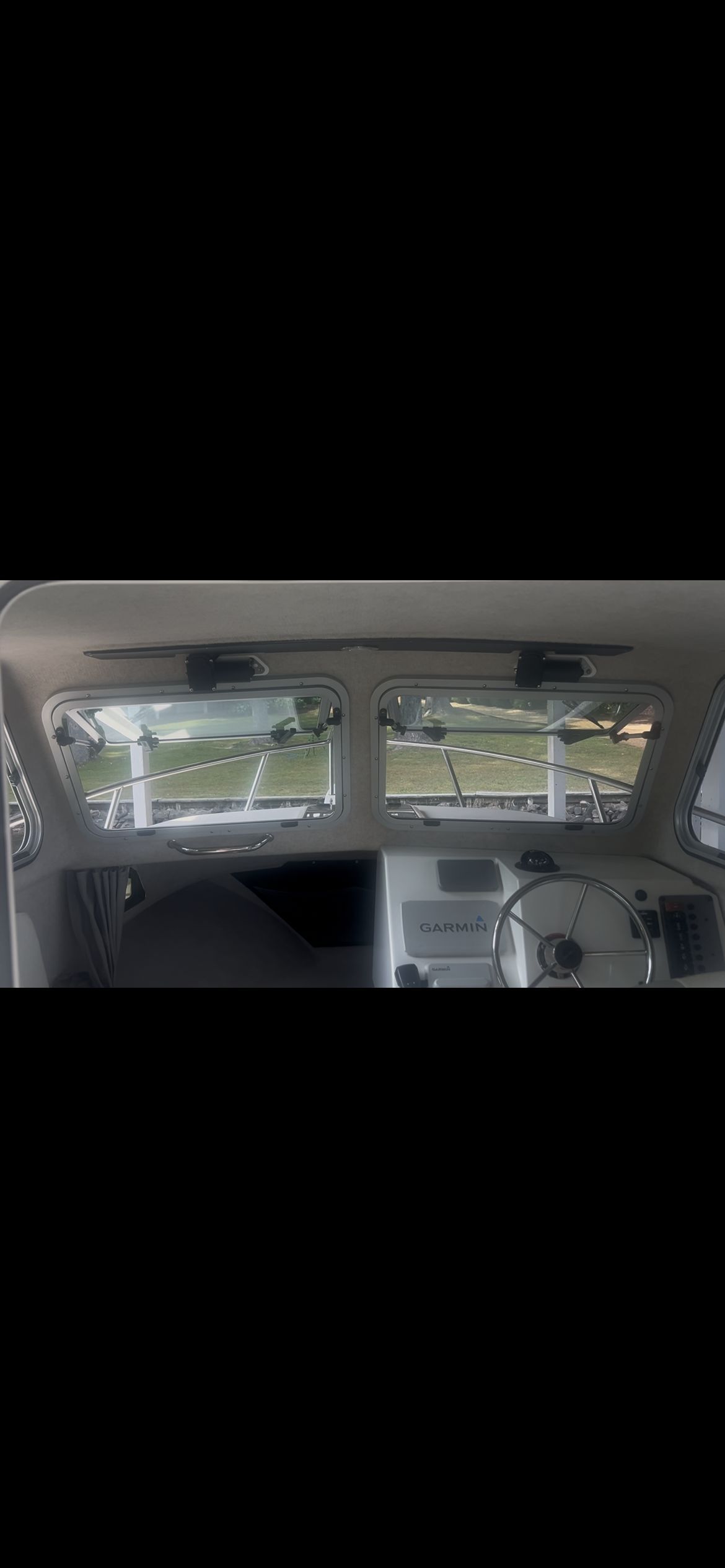 Interior view of a Parker 2320 Sport Cabin with steering wheel and windows.