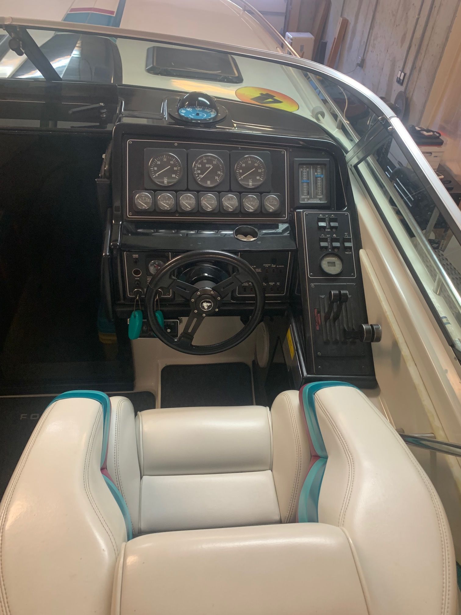 The cockpit of a 1988 Formula 311 SR1 with white seats and an instrument-filled dashboard.