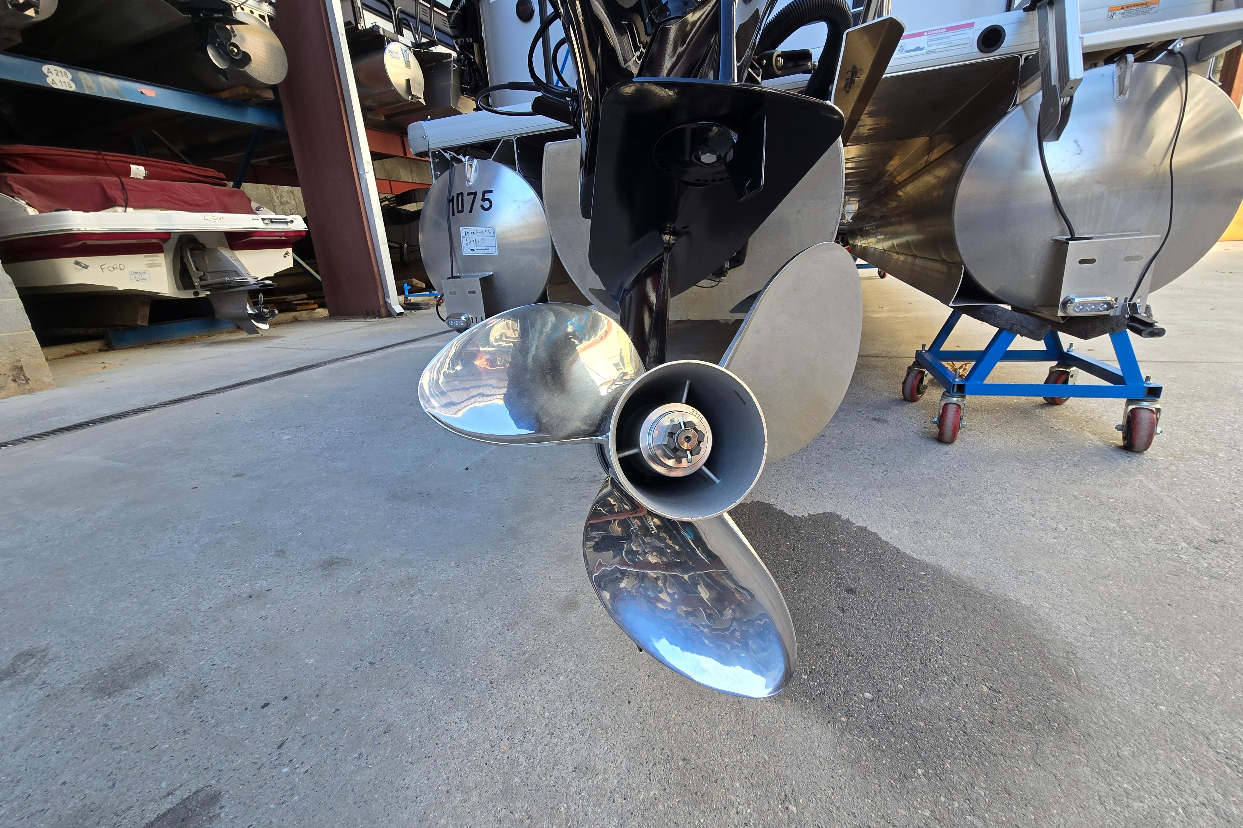 2024 Godfrey Sweetwater 2486 SB boat propeller in storage, showcasing shiny metal blades.