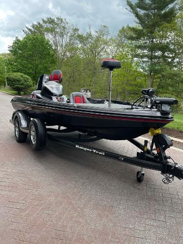2025 Ranger Z518 boat on trailer, parked on brick road, surrounded by lush greenery.
