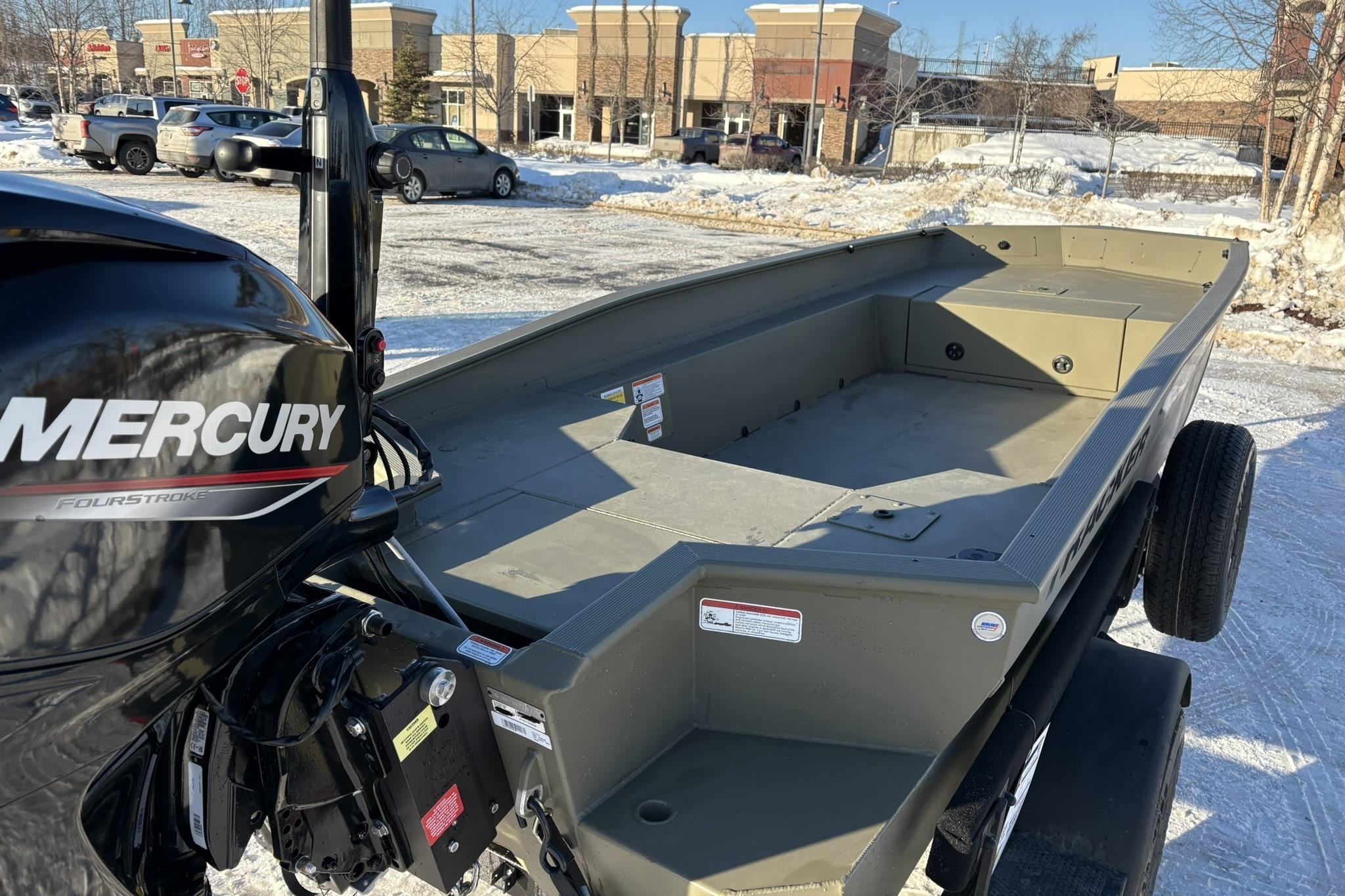 2025 Tracker Grizzly 1650 T Prairie Wings Edition boat with Mercury engine in snowy parking lot.