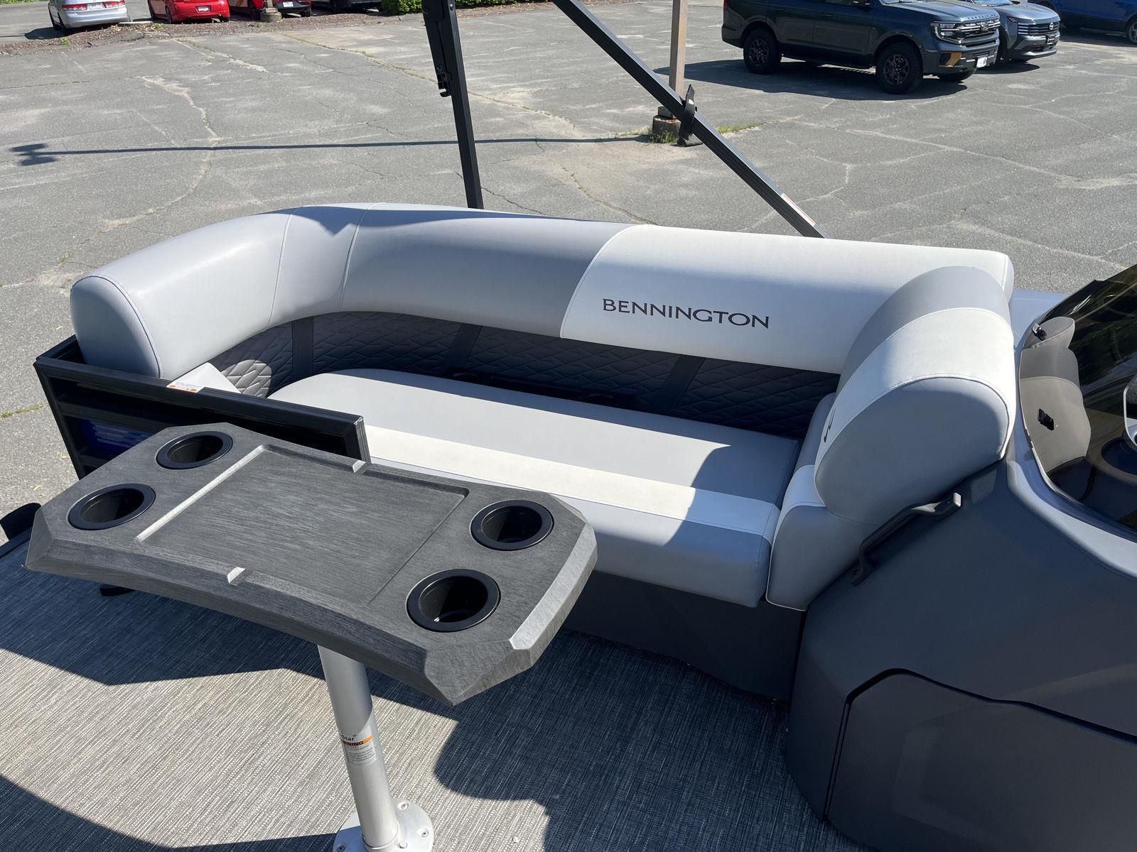 The image shows a gray seating area on a Bennington S20 boat, with a table featuring cup holders.