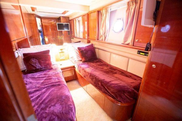 Luxurious cabin interior of 2003 Azimut 74 Solar yacht with twin beds and rich wood finish.