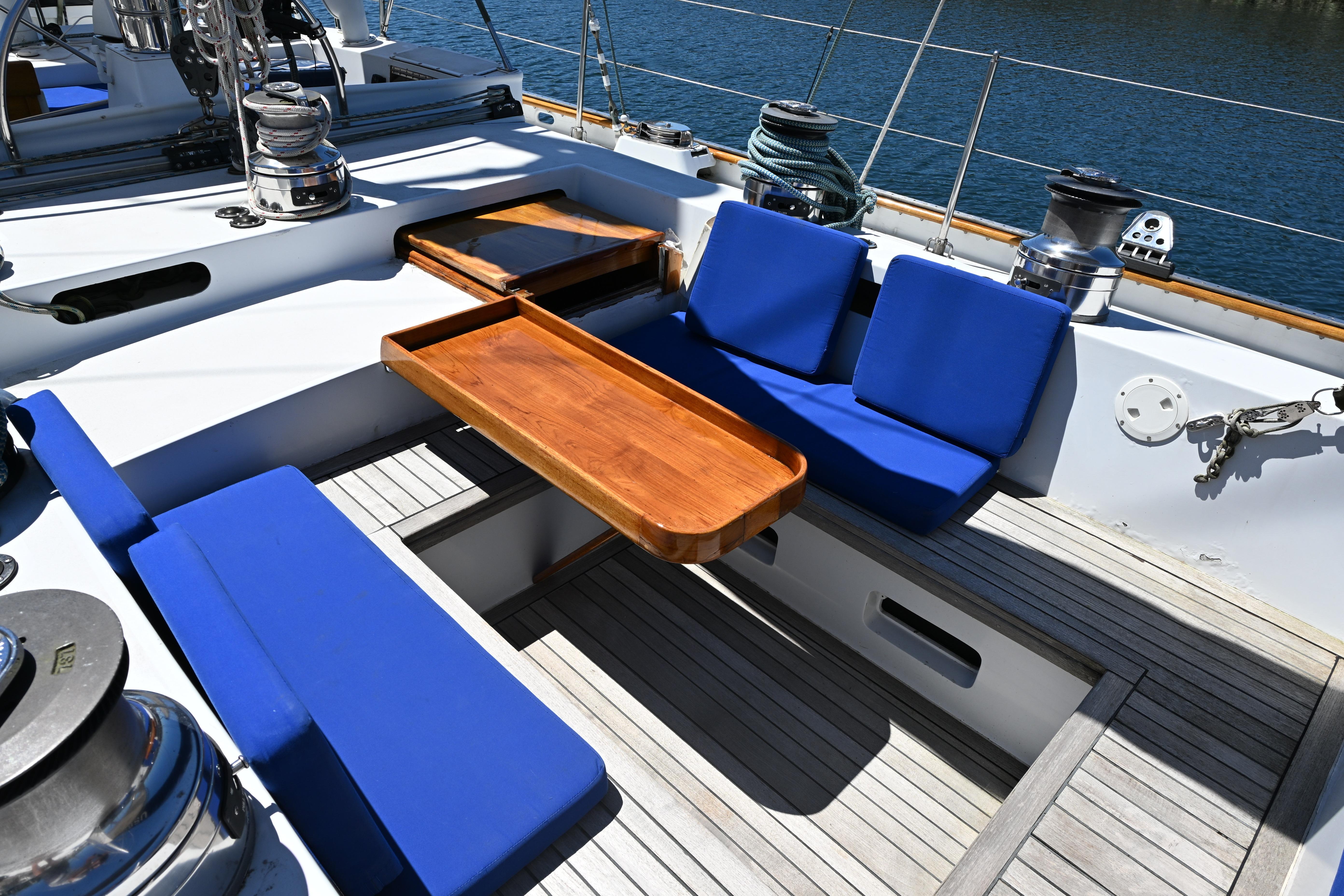 Cockpit of 1968 Abeking & Rasmussen Tripp 74 yacht with blue cushions and wooden table.