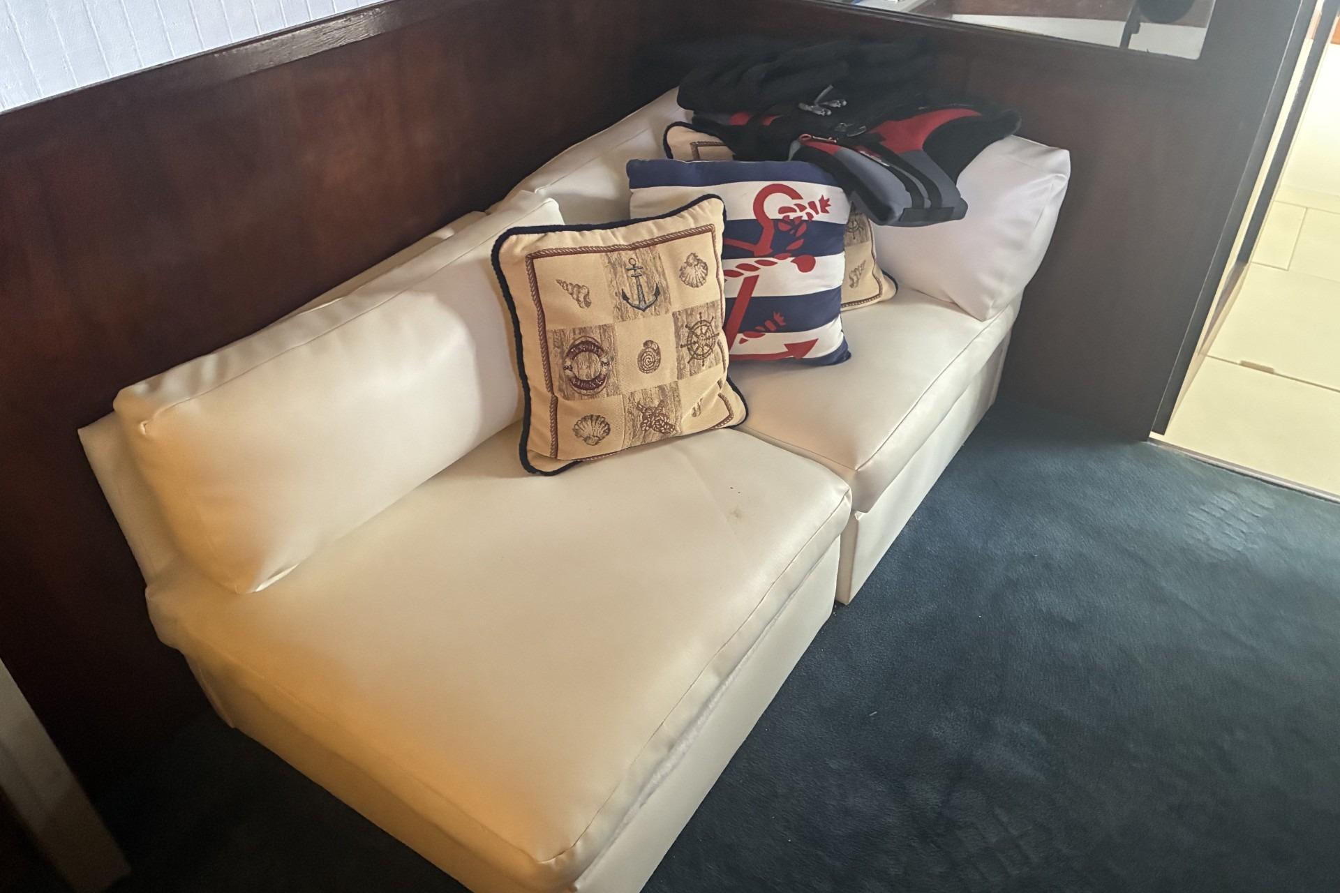 Interior of 1980 Chris-Craft 360 Commander with white seating and nautical-themed cushions.