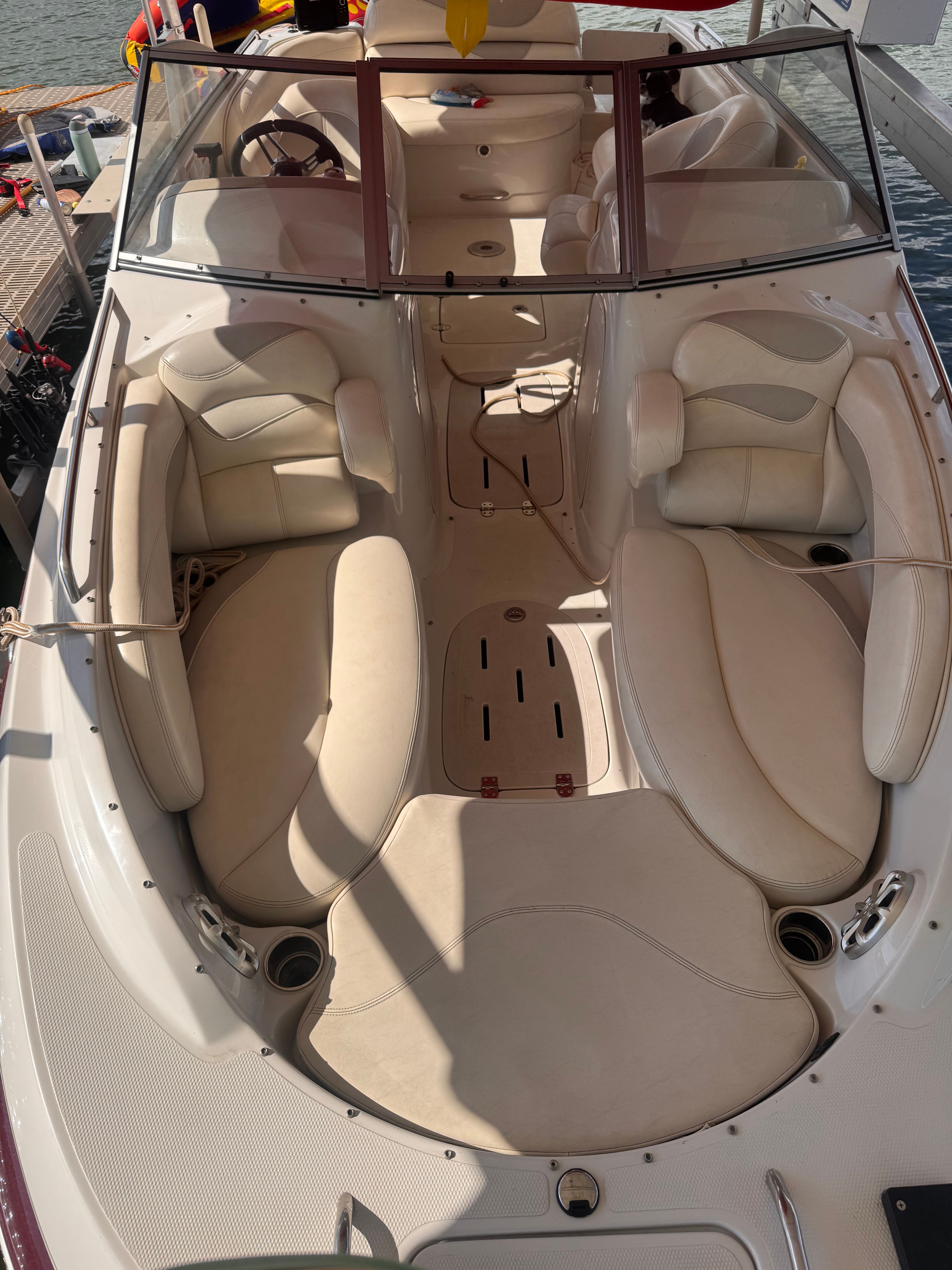 The image shows the cockpit of a 2011 Tahoe 228 boat with beige upholstery and a clear windshield.