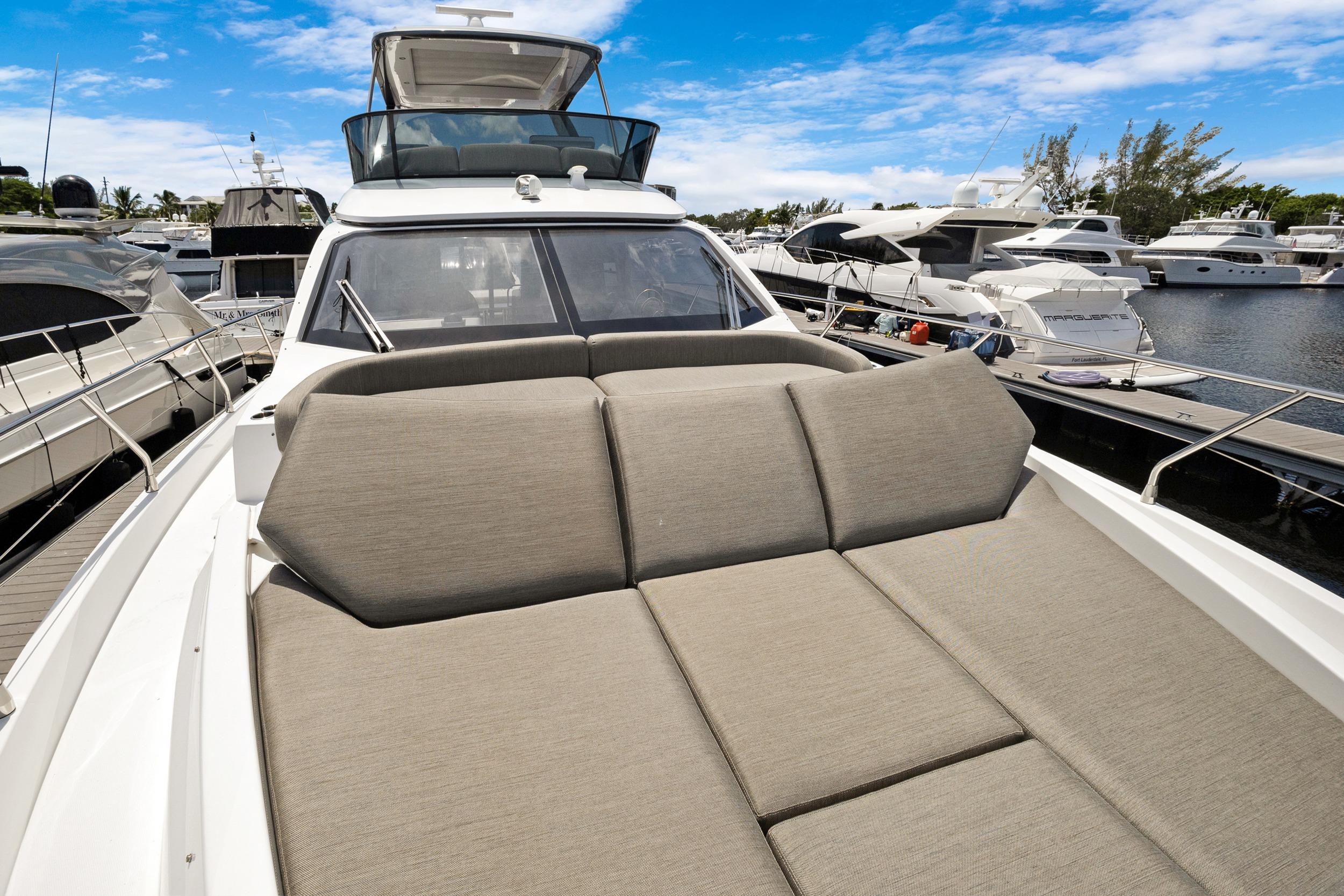 2024 Azimut Fly 53 yacht with spacious sunbed, docked at marina under blue sky.