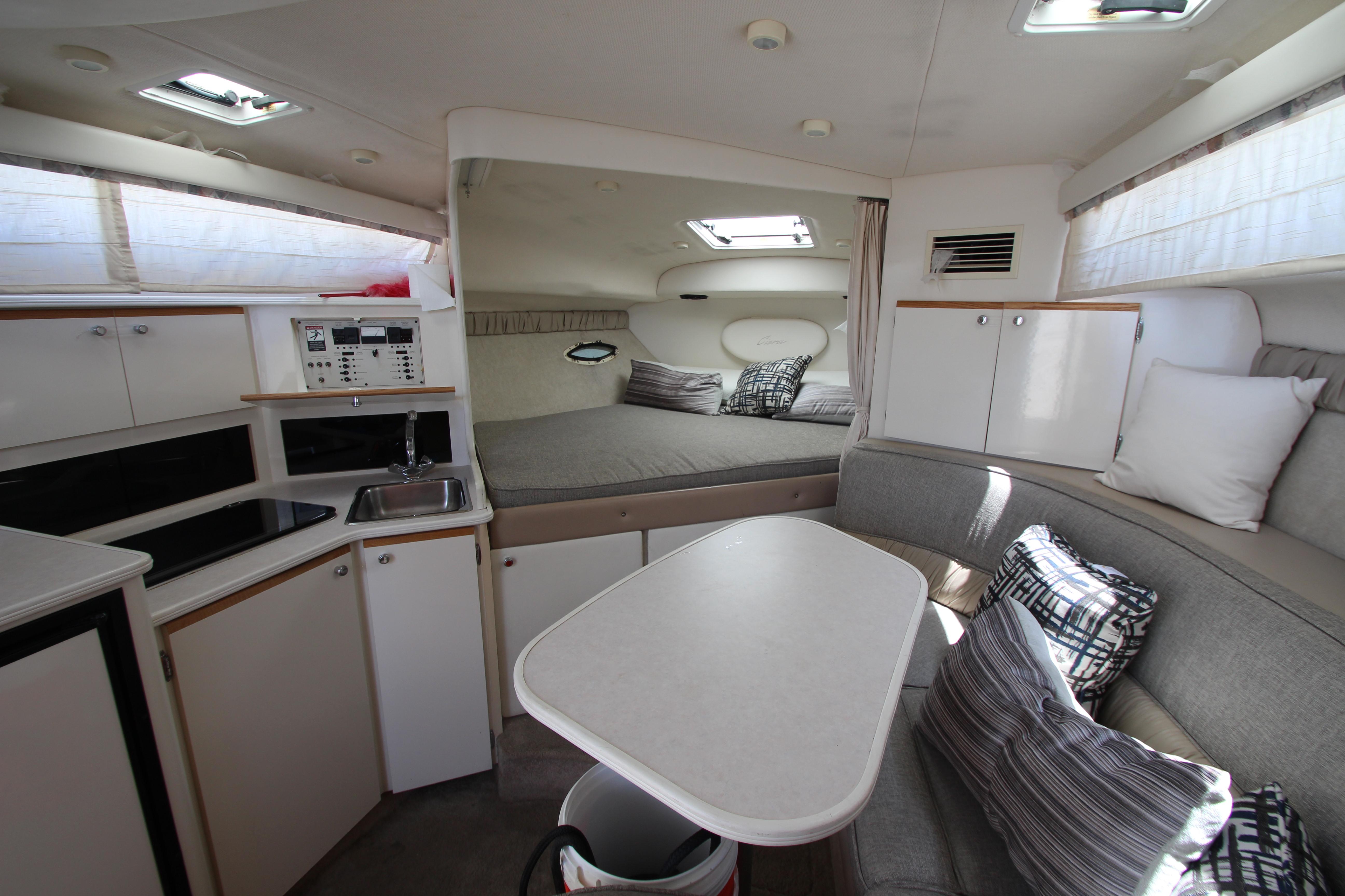 1999 Bayliner 3055 Ciera cabin interior with kitchenette, seating, and sleeping area.