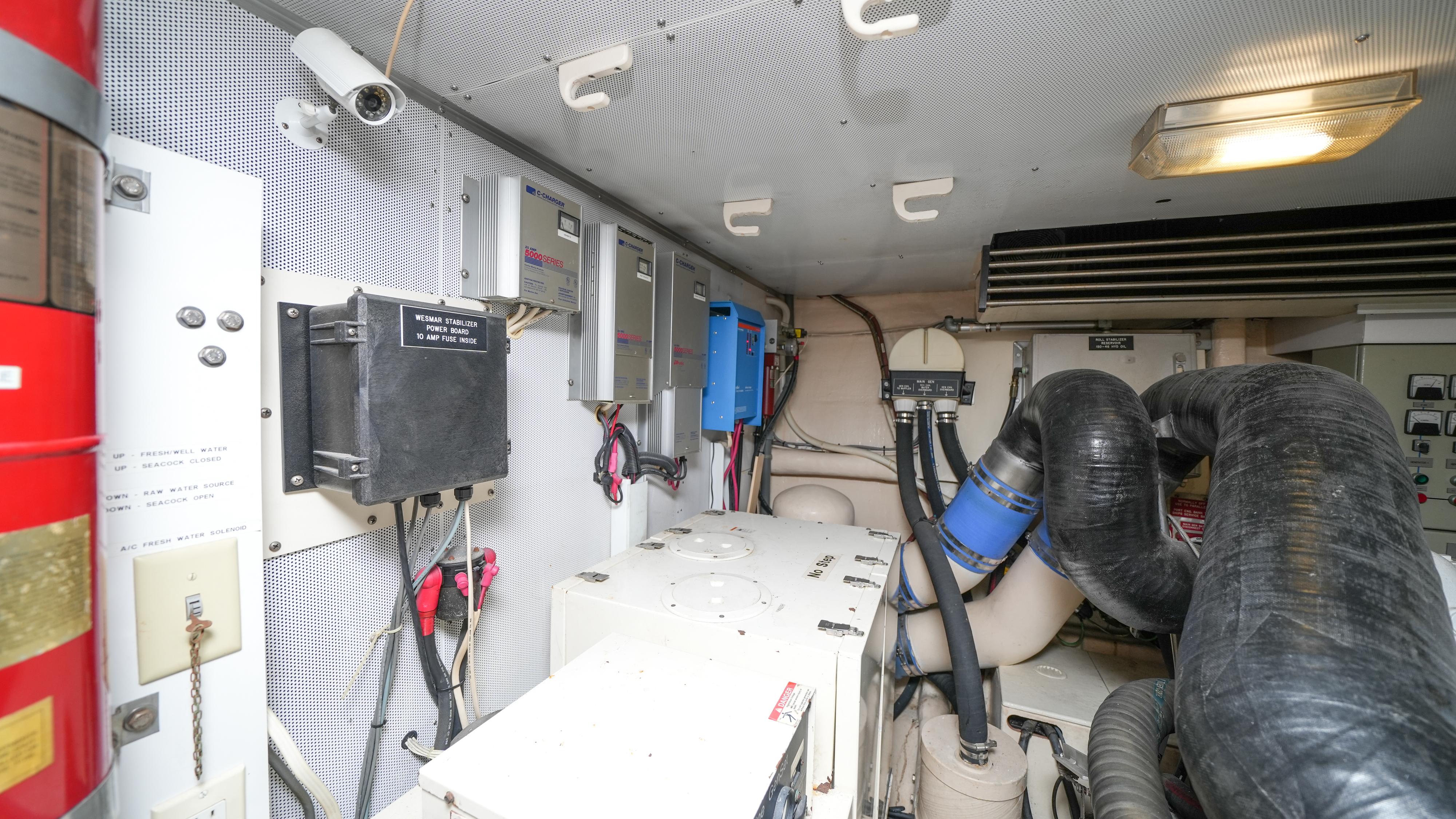 Engine room of a 2002 Queenship 70 Baretta yacht with various mechanical components.