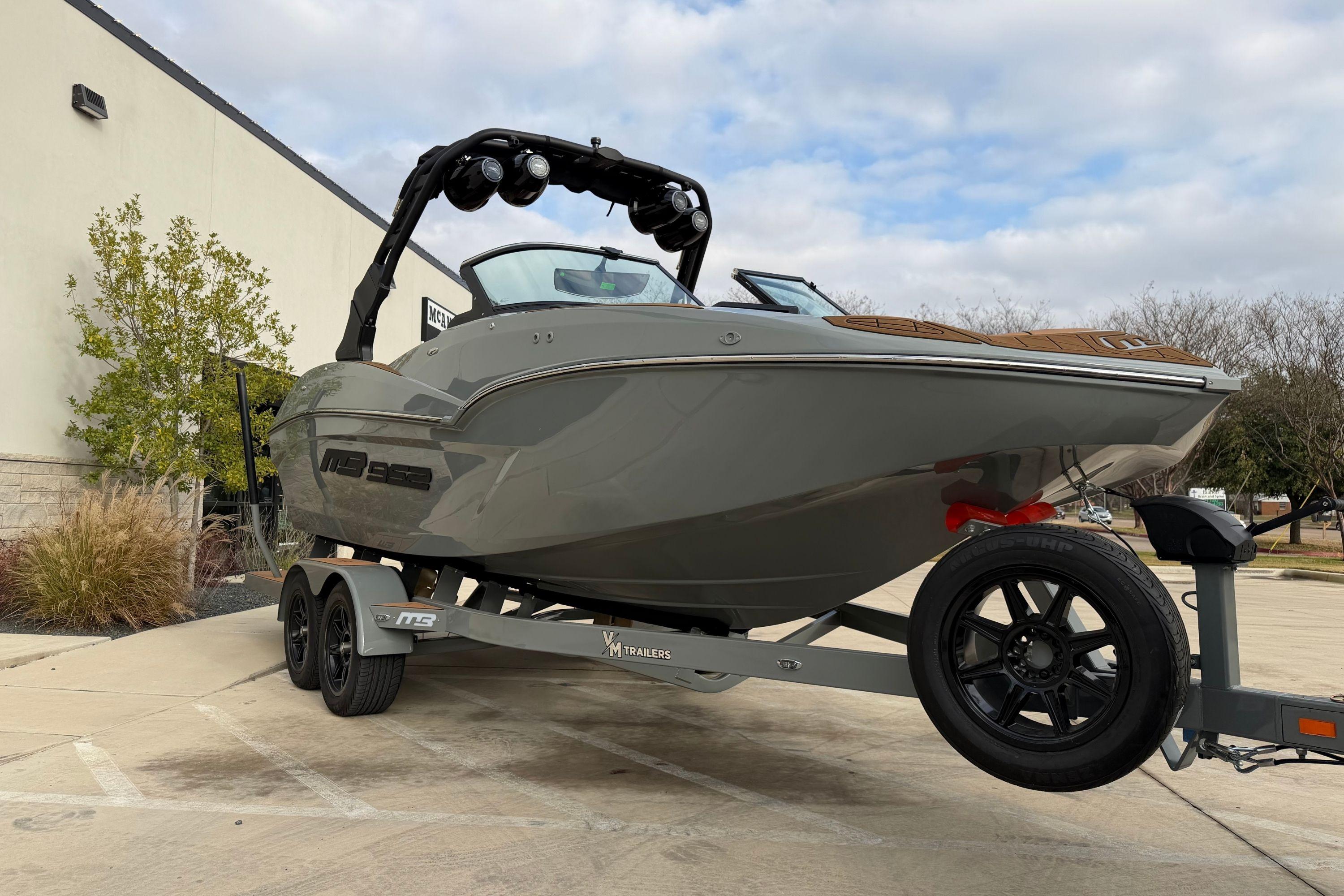 2026 MB B52 21 Alpha boat on trailer, parked outdoors, showcasing sleek design.