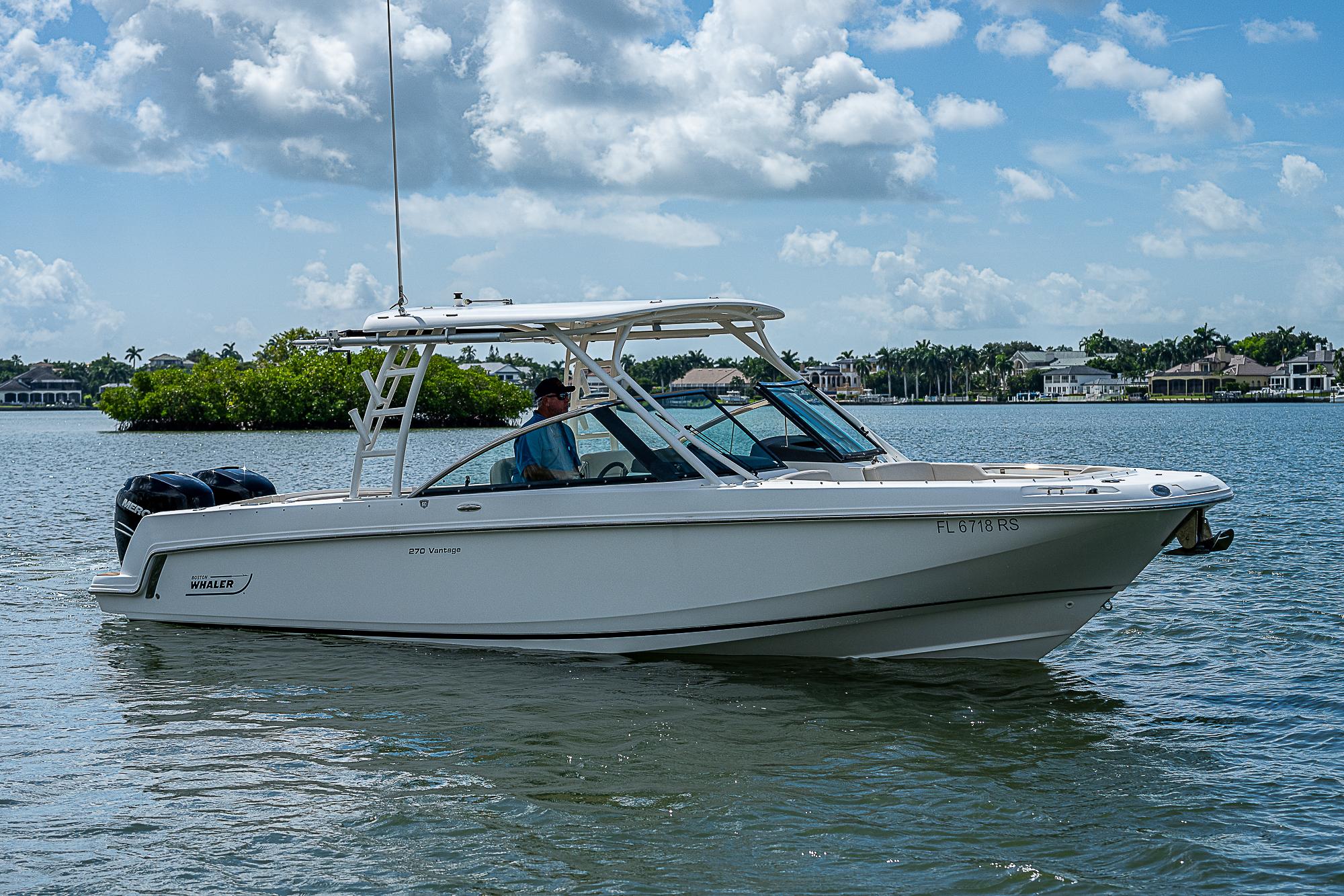 2018 Boston Whaler 270 Vantage boat on calm water under a cloudy sky.