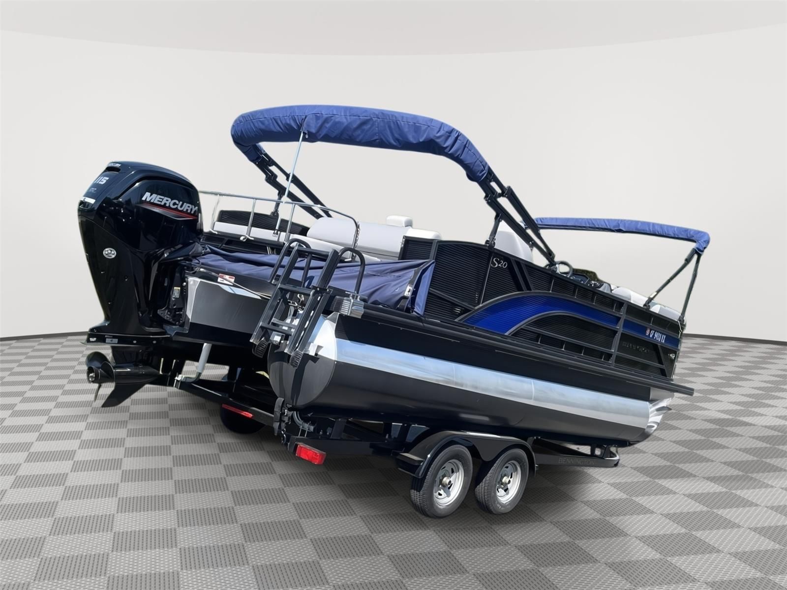 A 2025 Bennington S20 pontoon boat with a blue canopy and Mercury outboard motor on a trailer.