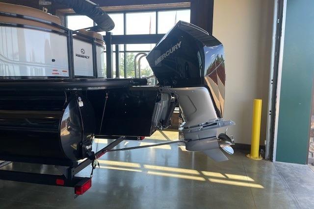 2026 Regency 230 DL boat with Mercury outboard motor in a showroom.