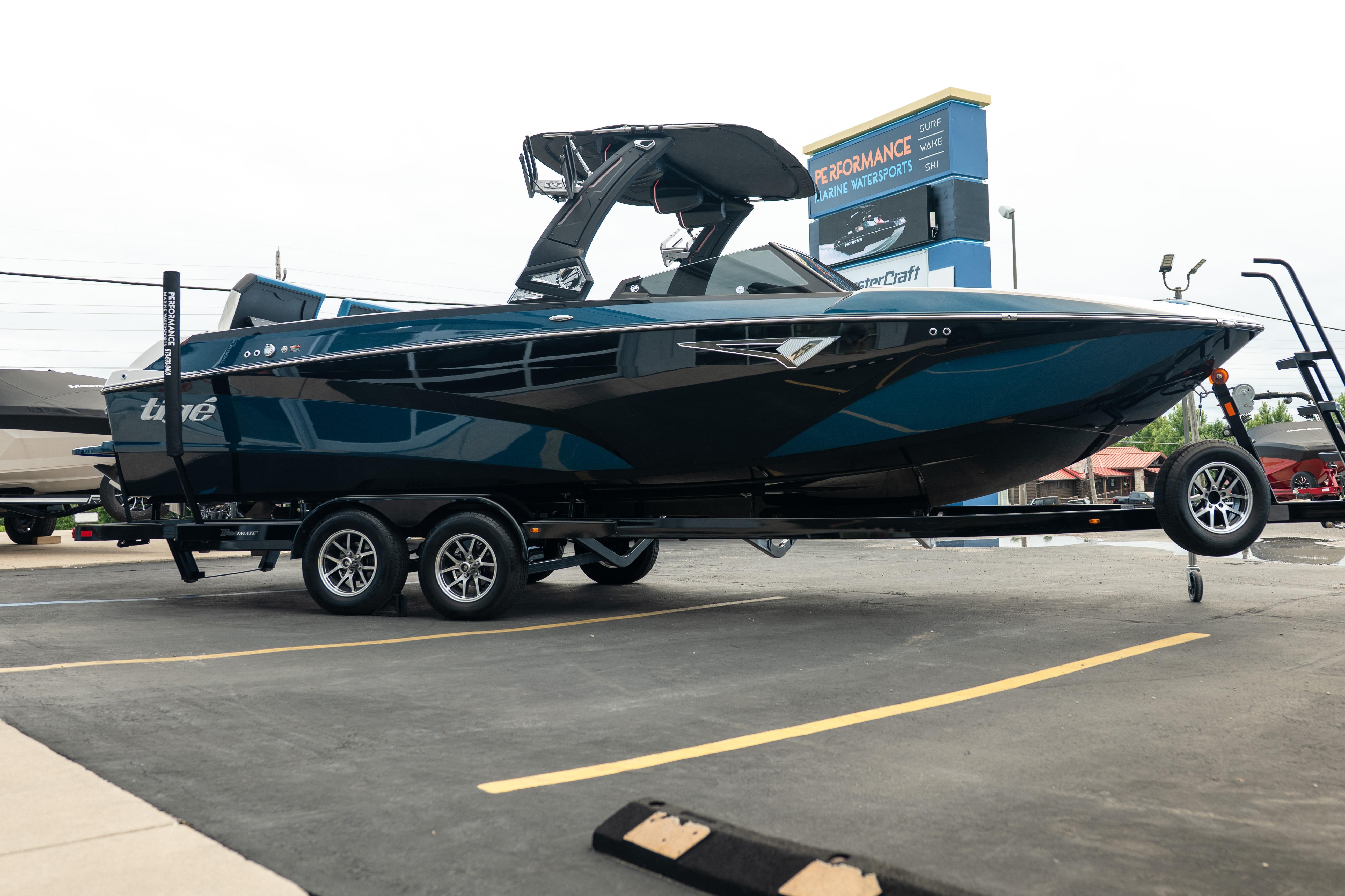 2024 Tigé Z5 boat on trailer in parking lot, side view.