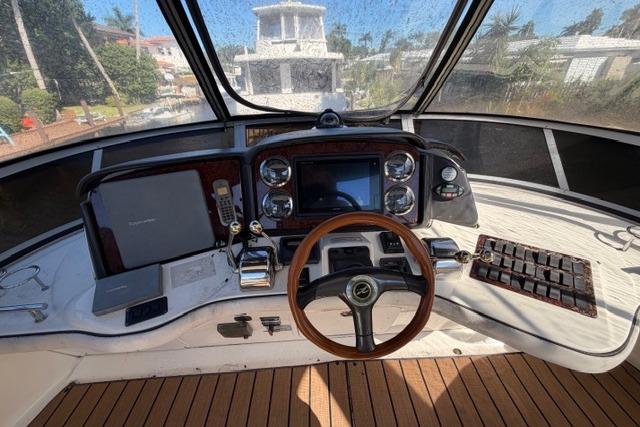 2004 Sea Ray 420 Sedan Bridge helm with wooden steering wheel and navigation controls.