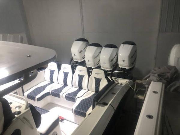 2019 Midnight Express 39 Cuddy boat with multiple outboard engines in a garage.