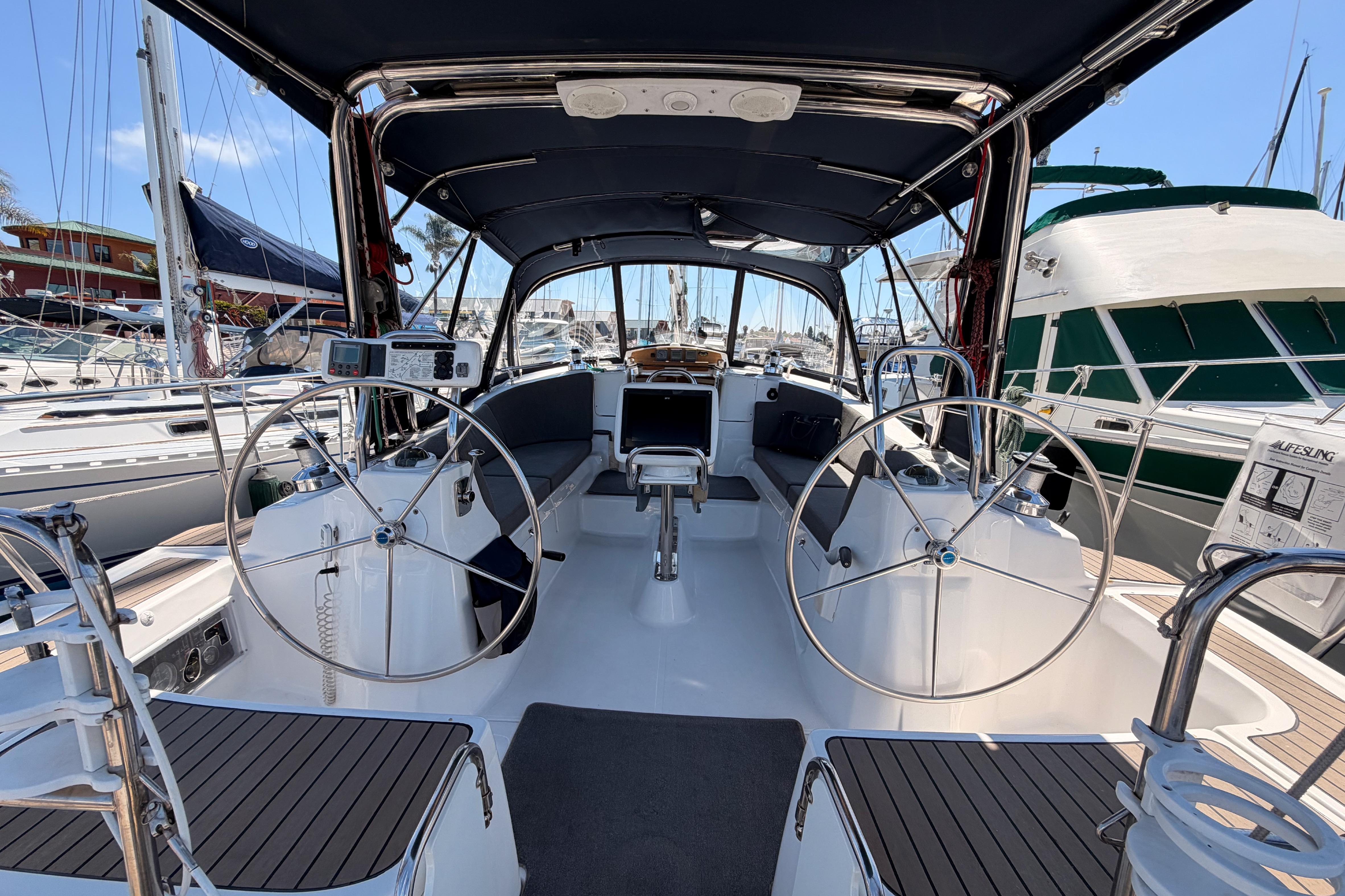2008 Hunter 45 Deck Salon yacht interior with dual steering wheels in marina setting.