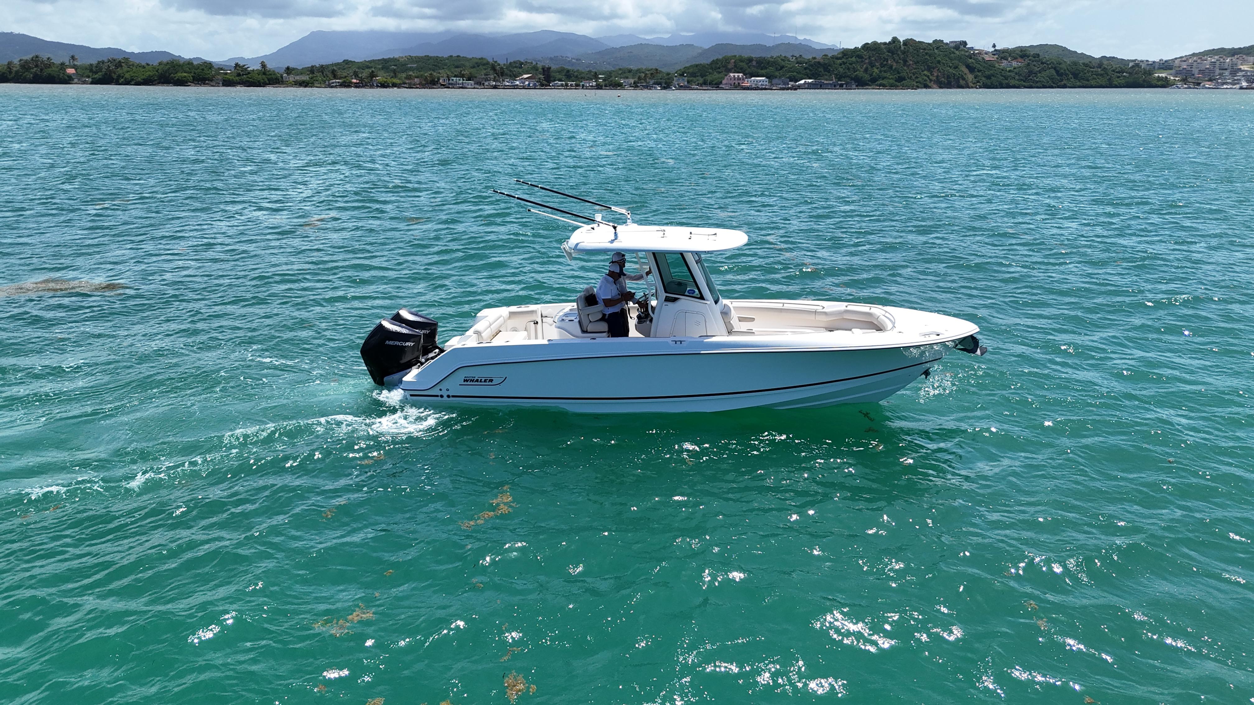 2022 Boston Whaler 280 Outrage cruising on clear blue water.