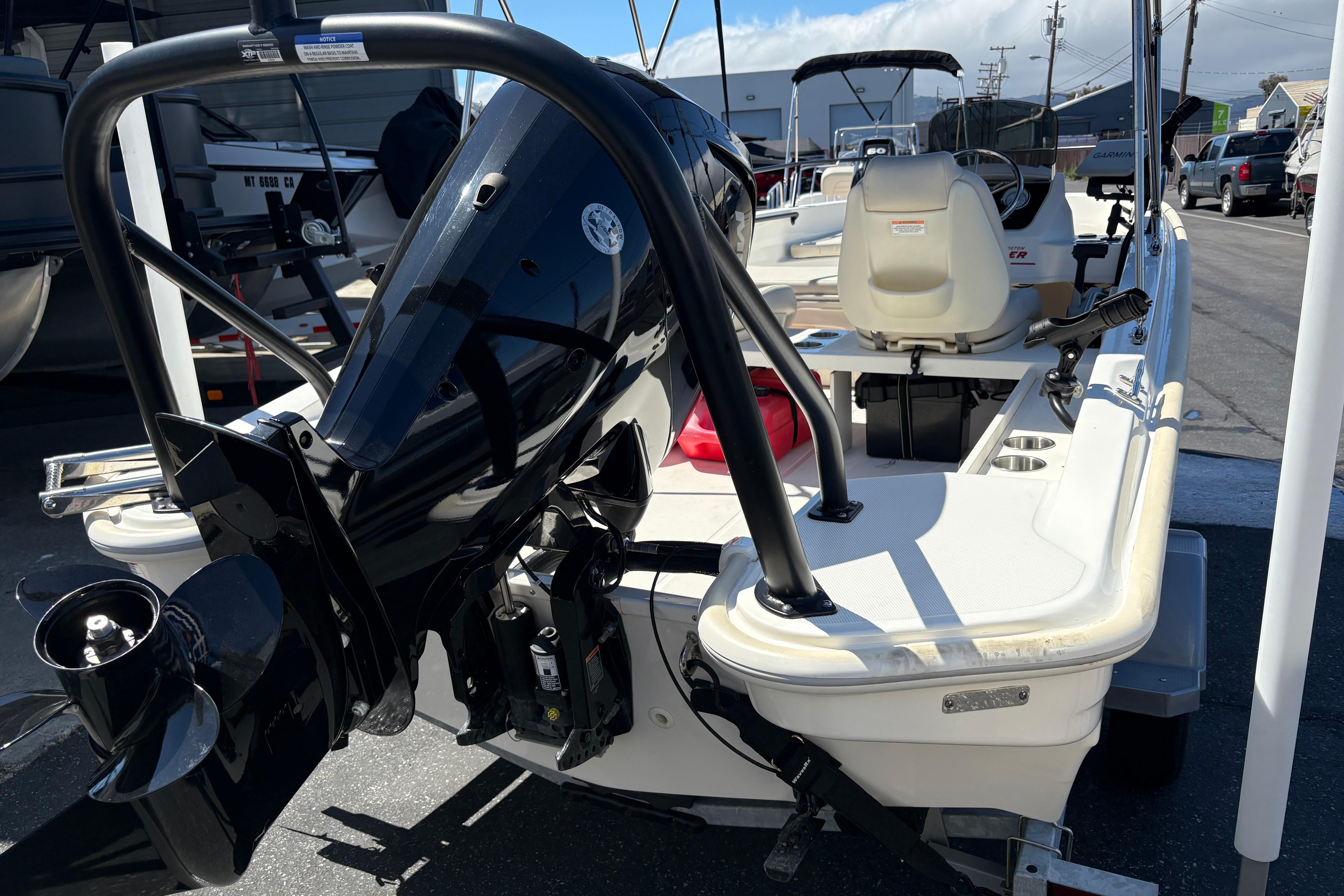 2024 Boston Whaler 160 Super Sport boat with outboard motor, docked in a marina.