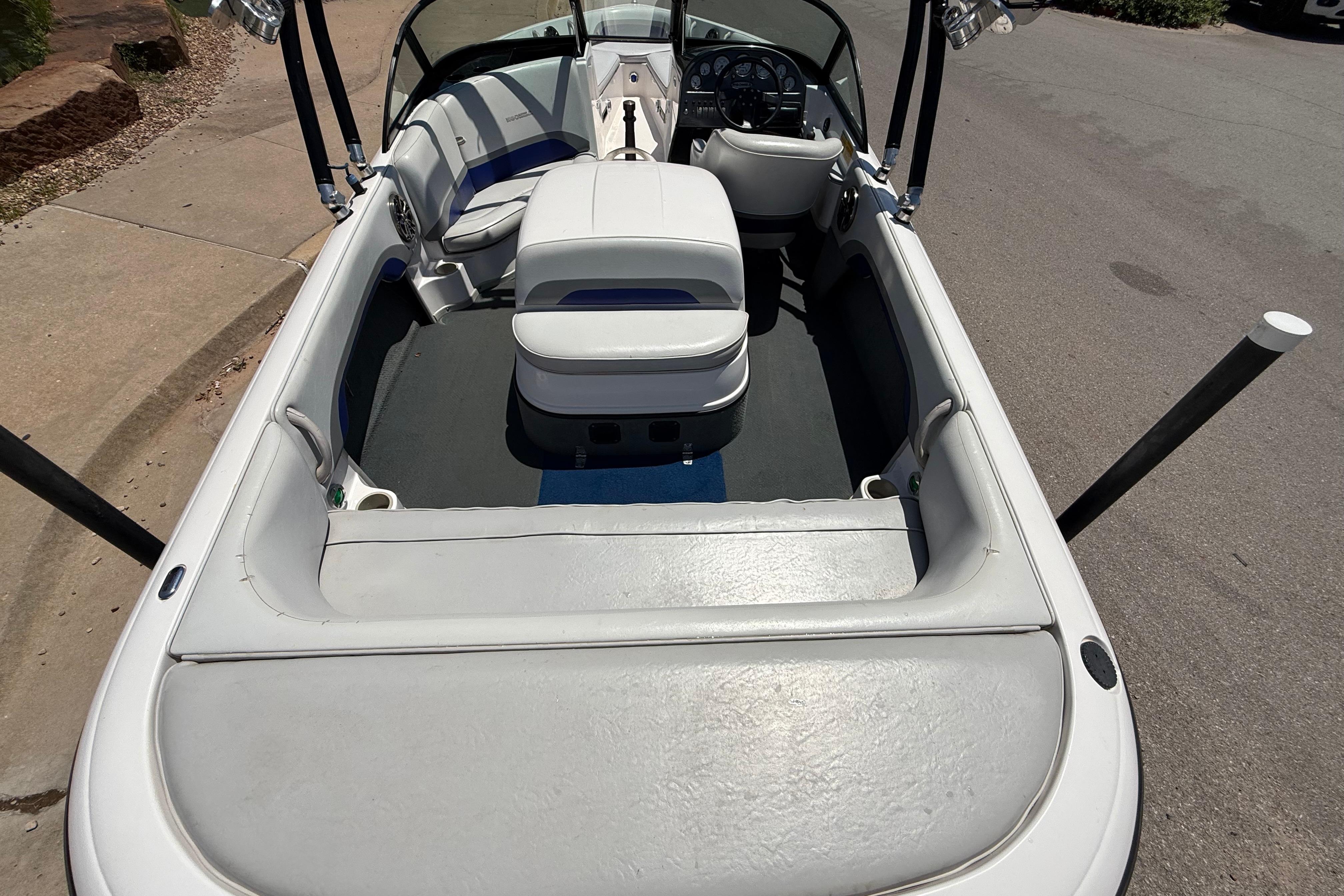 2001 Moomba Outback boat interior with white seating and steering wheel, parked on pavement.