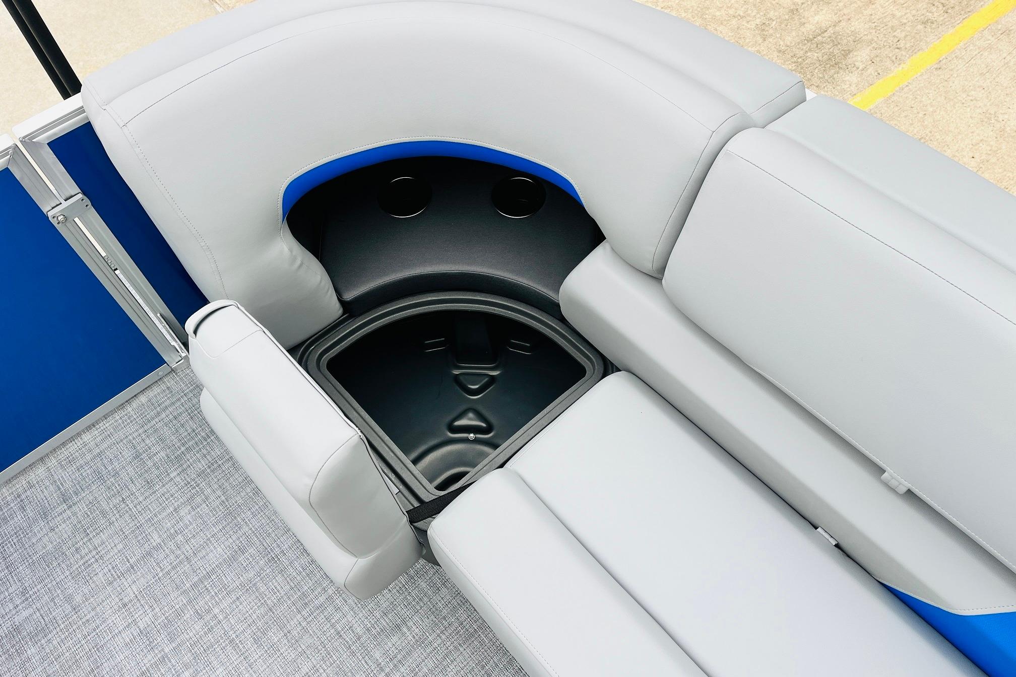 2026 Sun Tracker Party Barge 22 RF DLX seating with storage compartment, featuring gray upholstery.