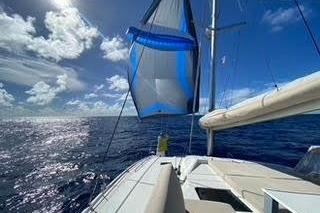 2022 Fountaine Pajot Elba 45 Catamaran sailing on open ocean under clear blue sky.