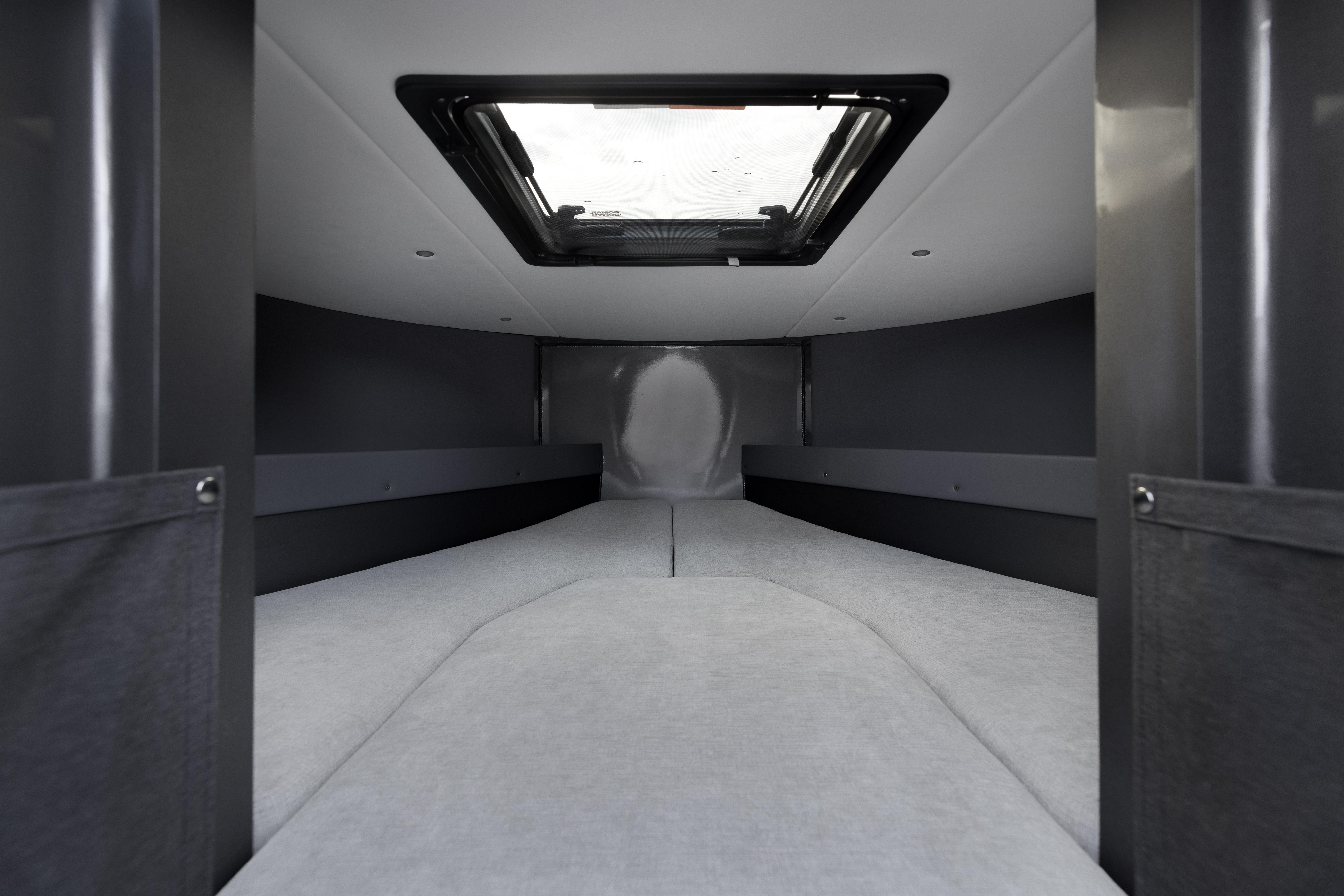 Interior cabin of 2026 Jasper Marine Defender 22 boat, featuring a skylight and modern design.