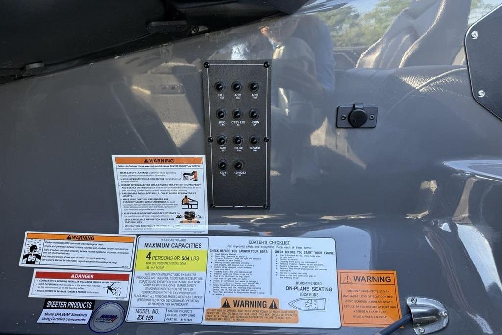 Control panel and warning labels on a 2026 Skeeter ZX150 boat dashboard.