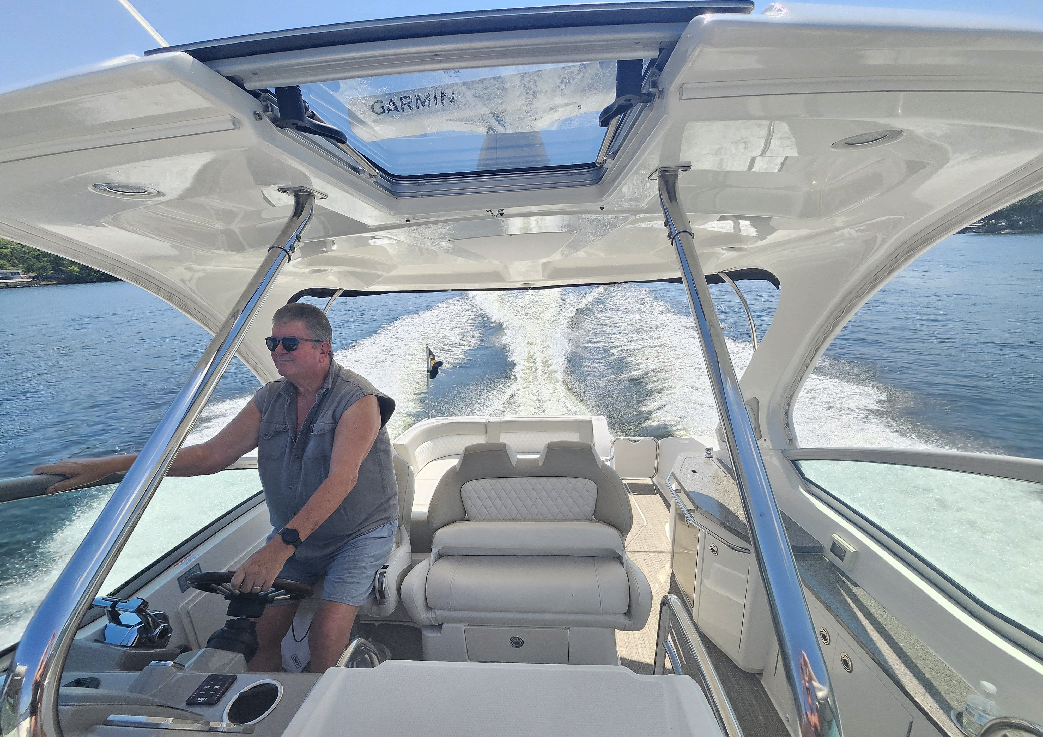 Man piloting 2014 Chaparral 330 Signature on open water.
