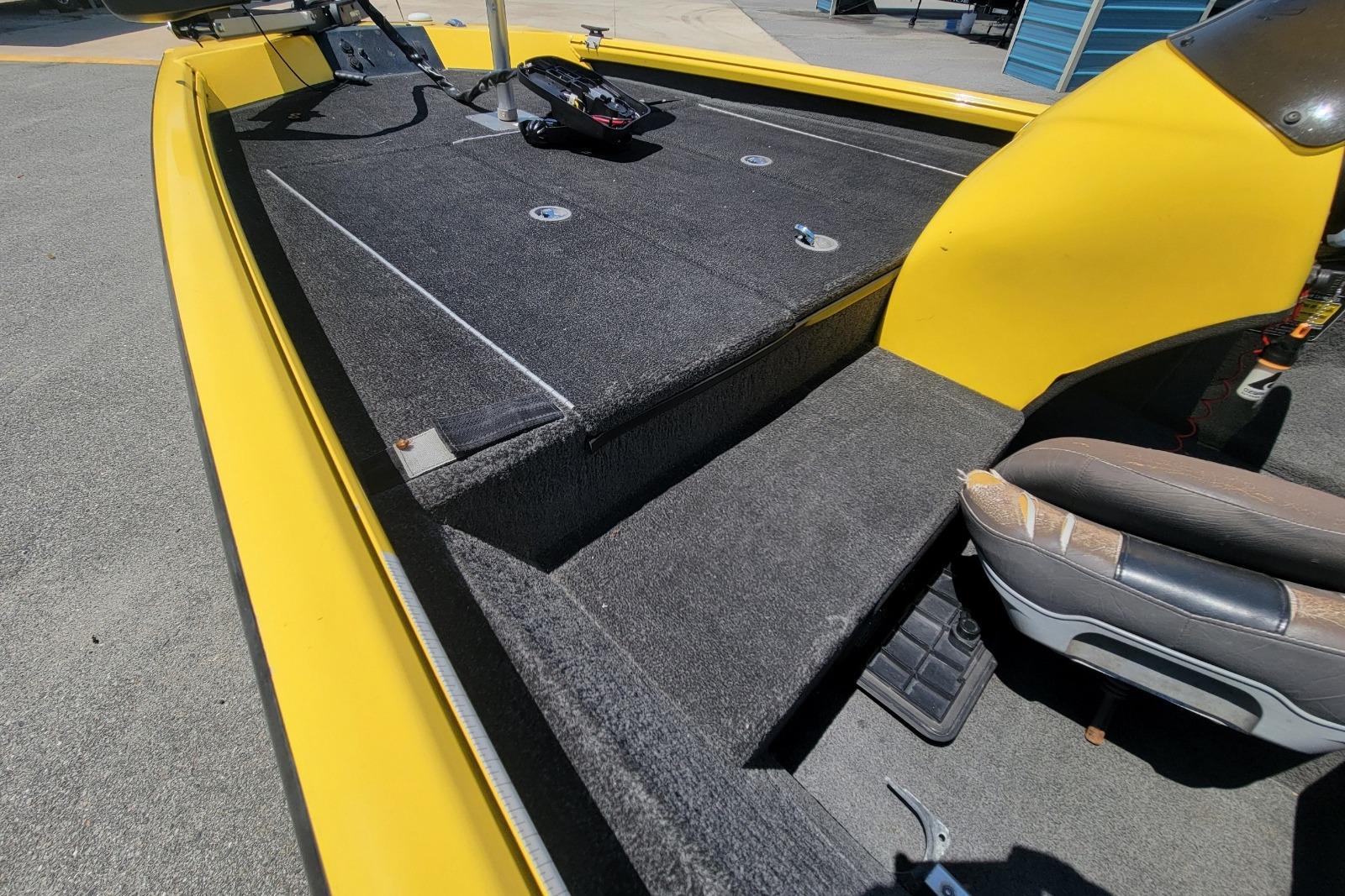 Yellow 2011 Excel 1751 F4 boat interior with carpeted deck and seating.