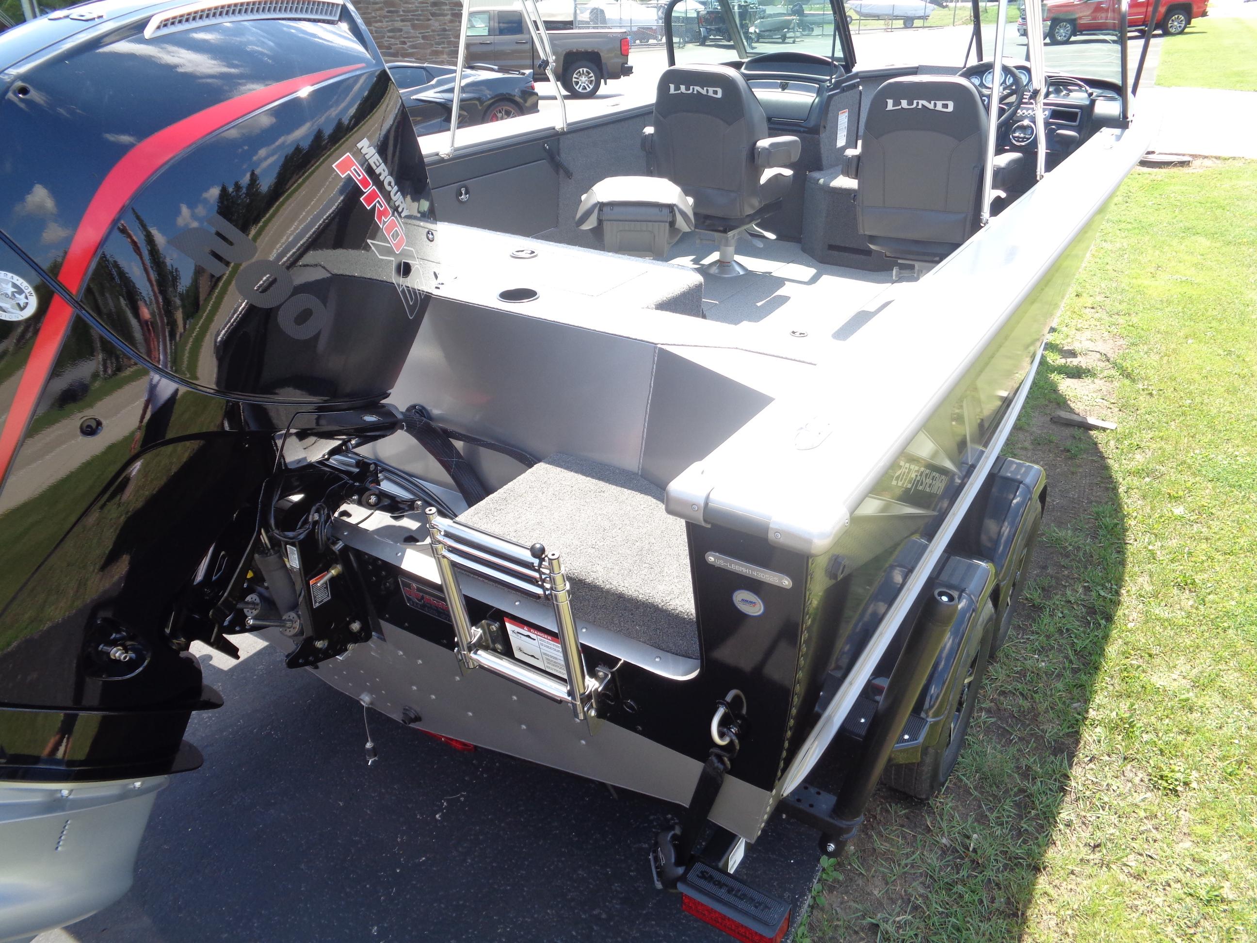 2025 Lund 2075 Fisherman boat with Mercury Pro engine, parked on grass.