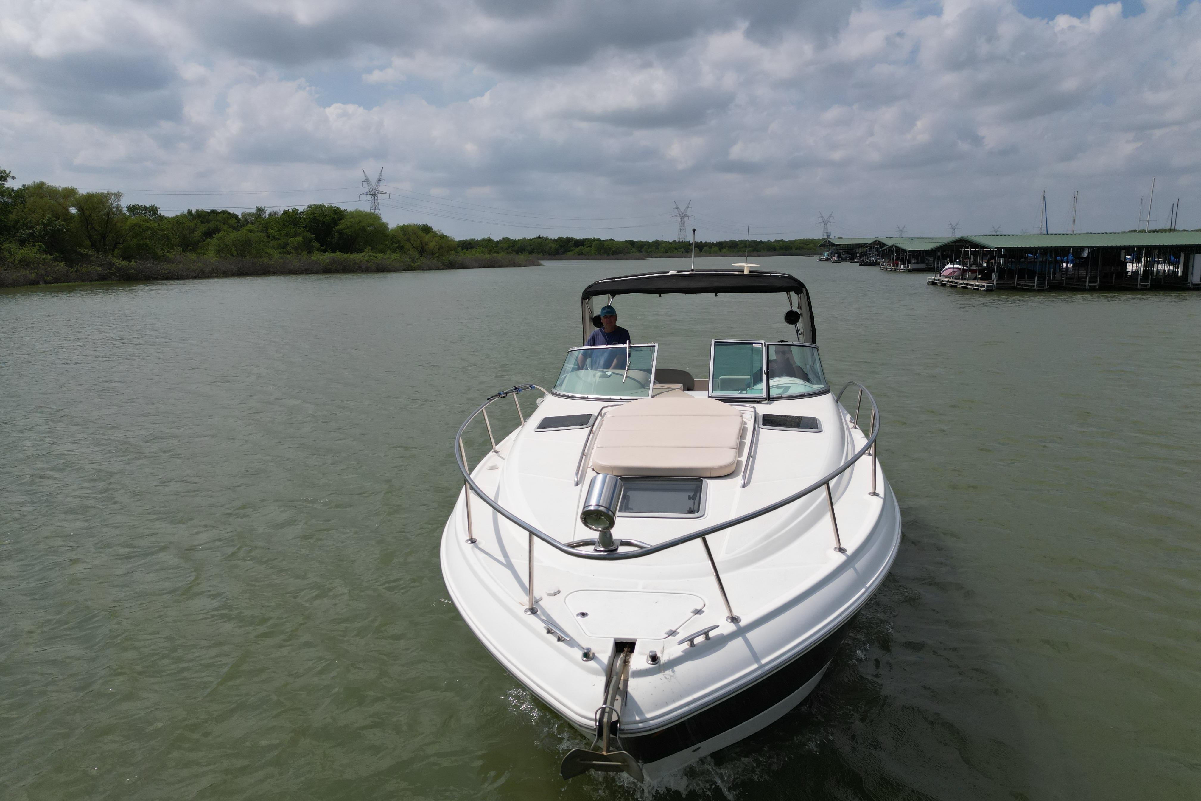 2006 Chaparral 330 Signature boat cruising on a calm river under cloudy skies.