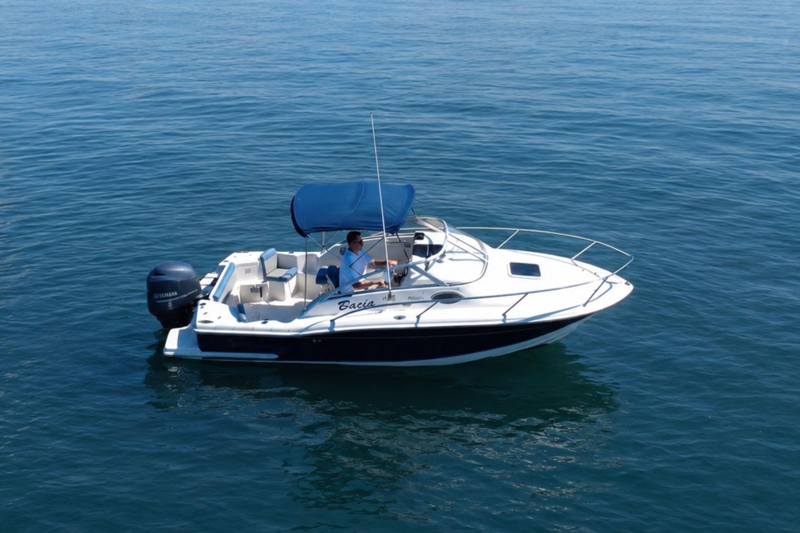 2008 Scout 222 Abaco boat with blue canopy cruising on calm water.