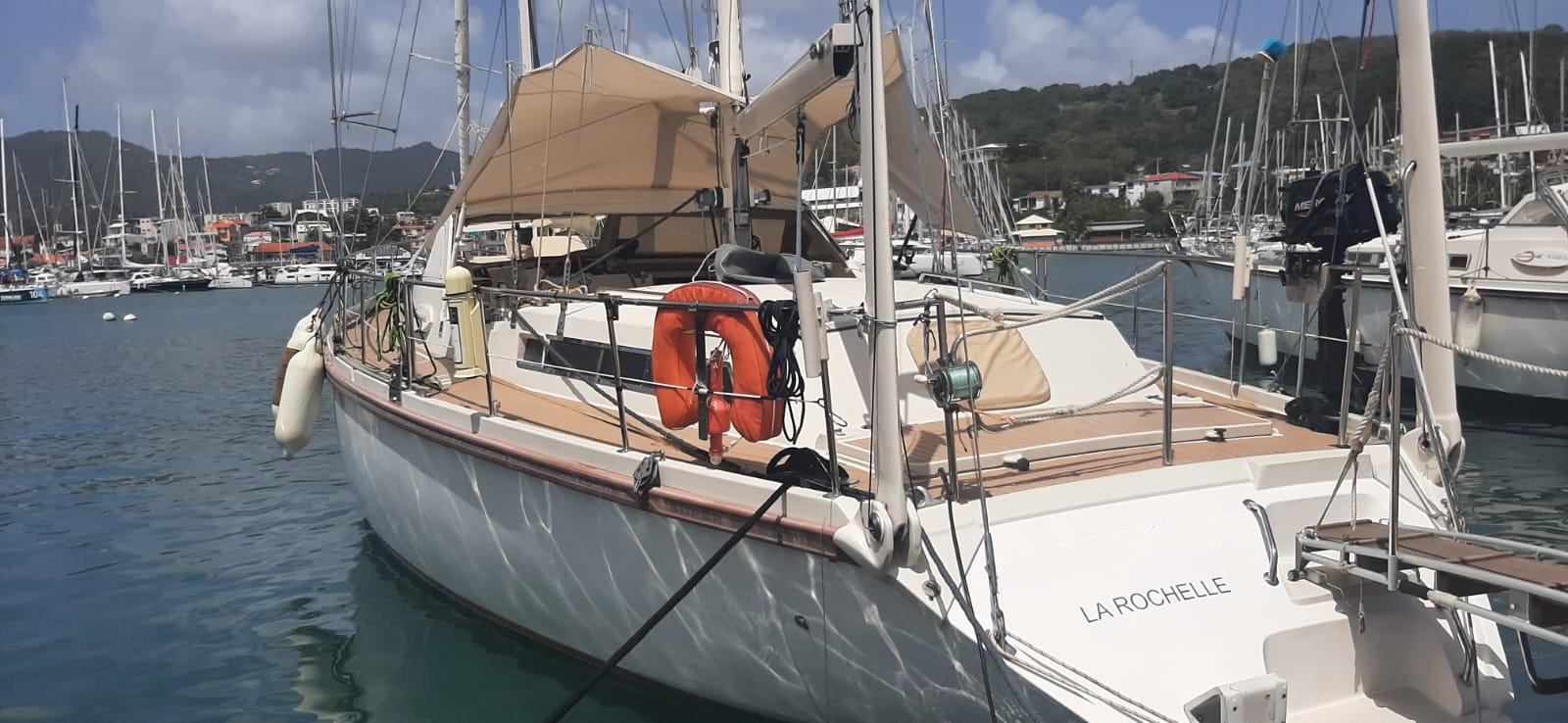 Sailboat Amel Super Maramu 1998 docked in marina, surrounded by other boats.