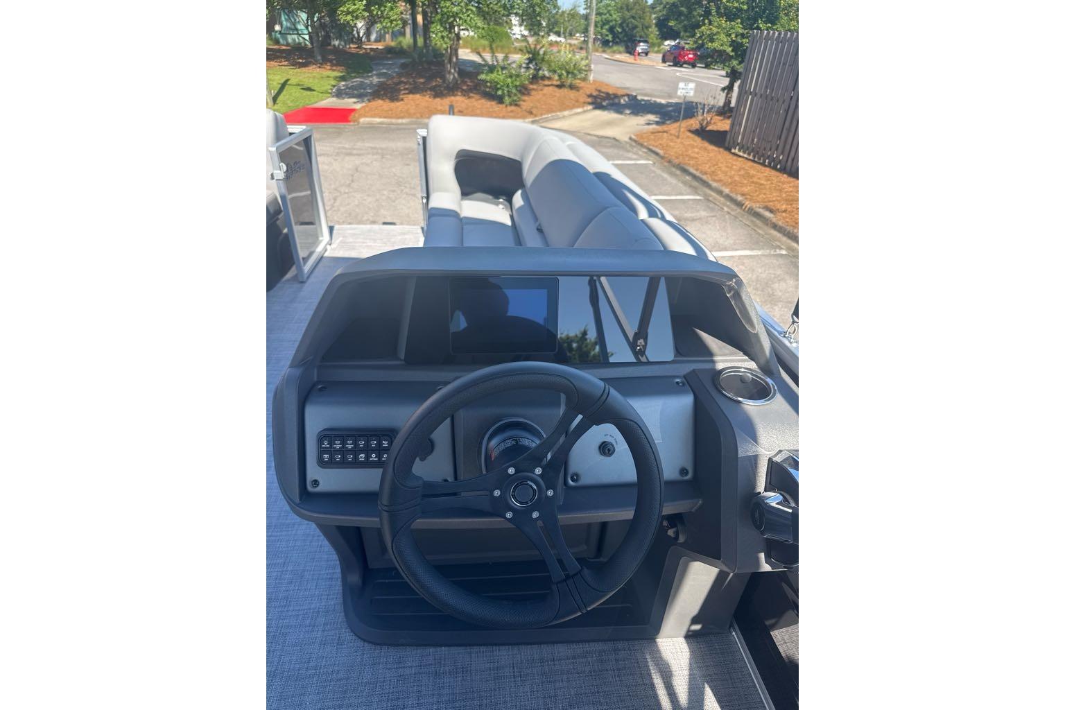 2026 Sun Tracker Party Barge 20 DLX dashboard with steering wheel and seating area.