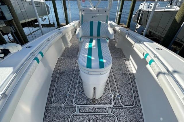 2002 Yellowfin 31 Center Console boat with teal-striped seating and textured flooring.