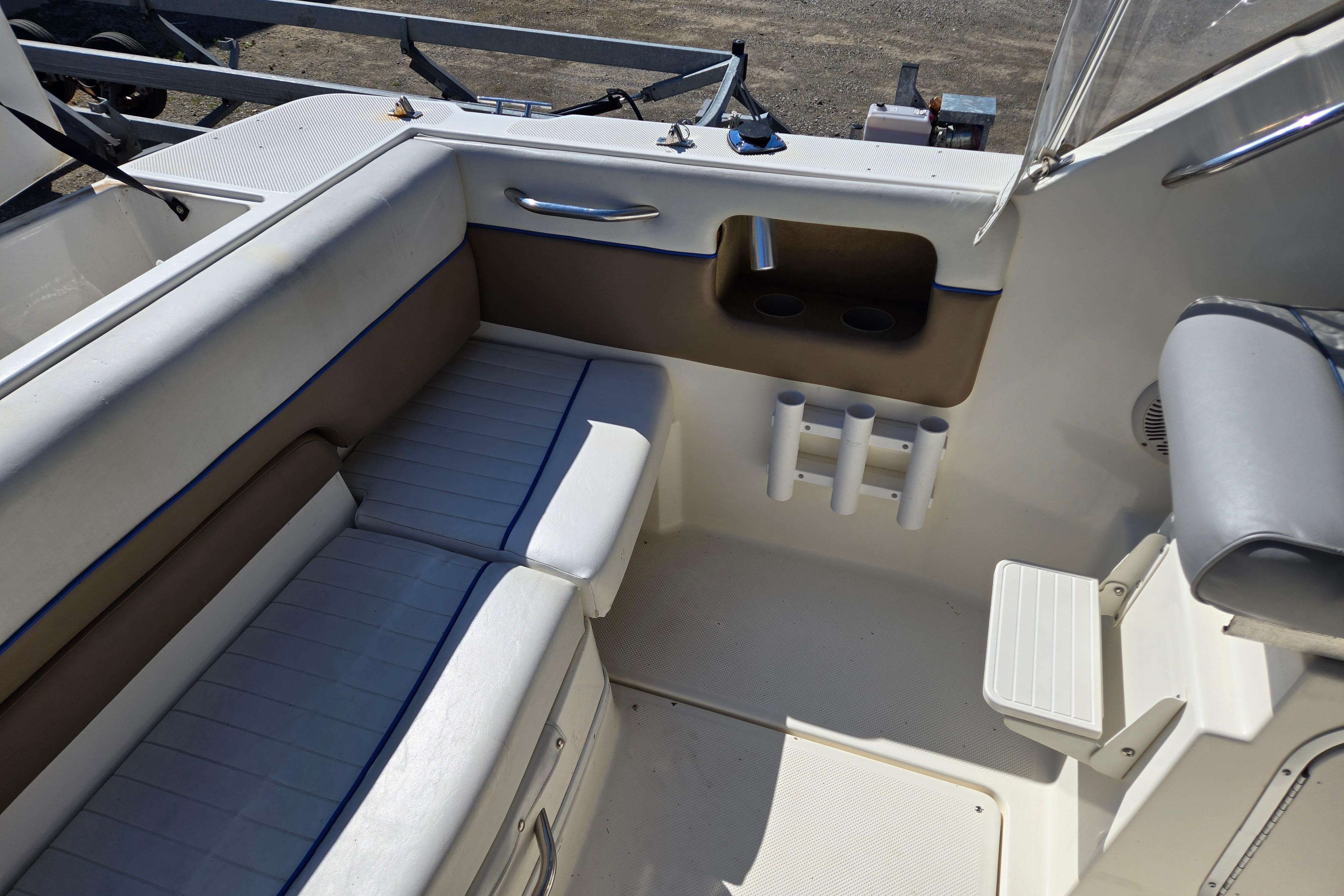 Interior of a 2006 Bayliner 222 Classic boat, featuring cushioned seating and cup holders.