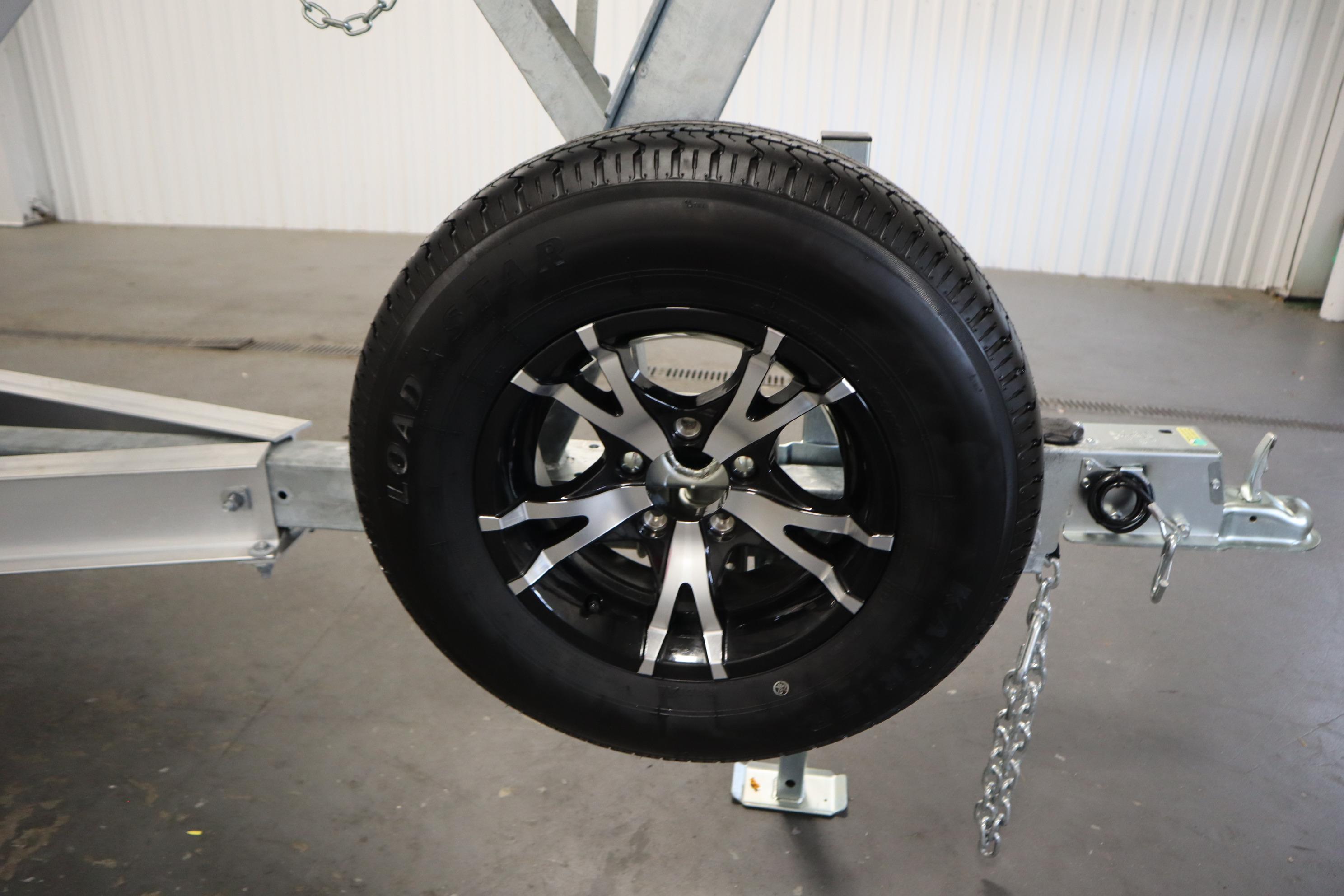 Trailer wheel for 2026 Sea Fox 228 Commander boat, featuring a sleek black and silver rim.