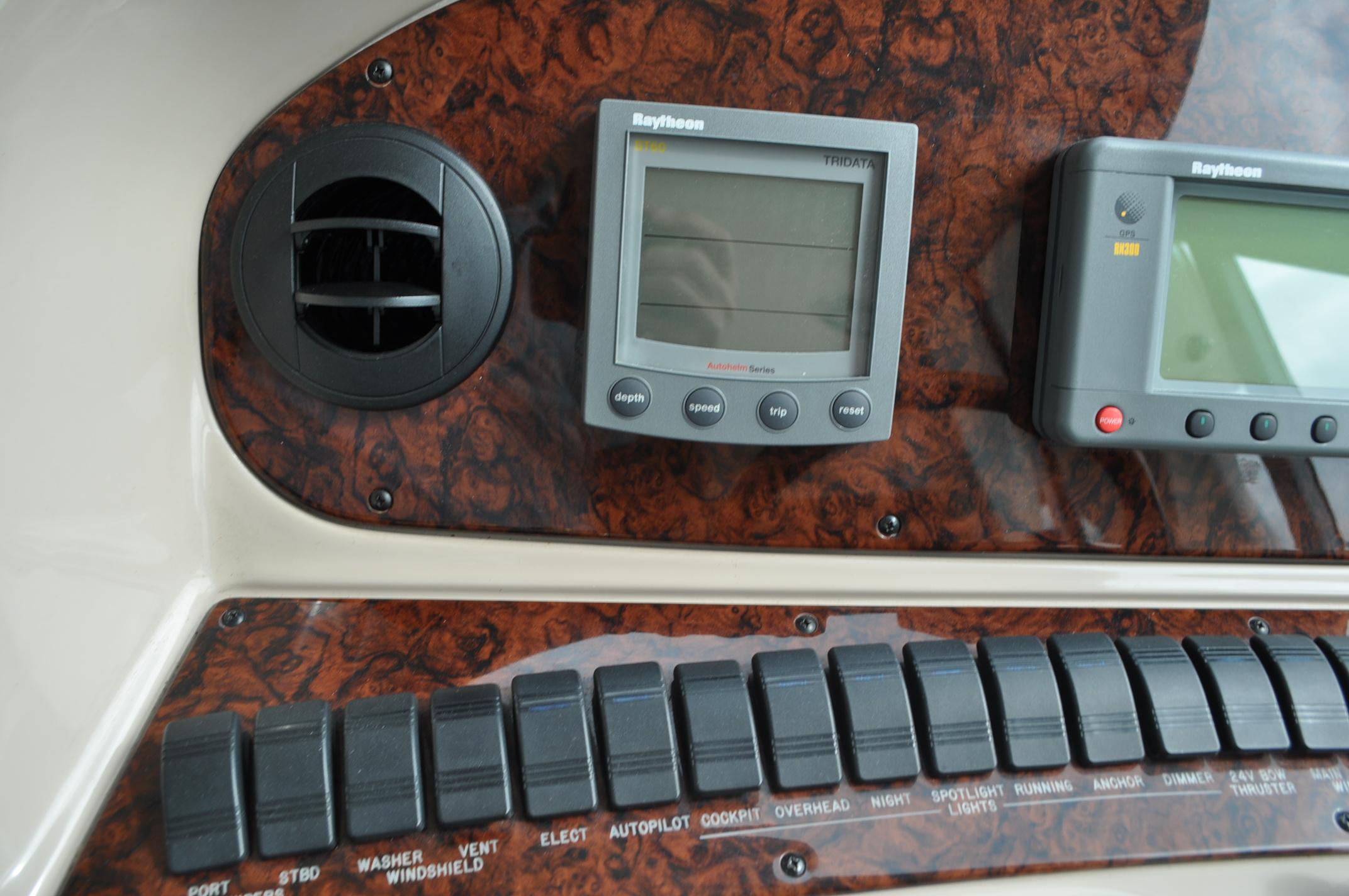 Control panel of a 2002 Sea Ray 480 Motor Yacht with Raytheon displays and switches.