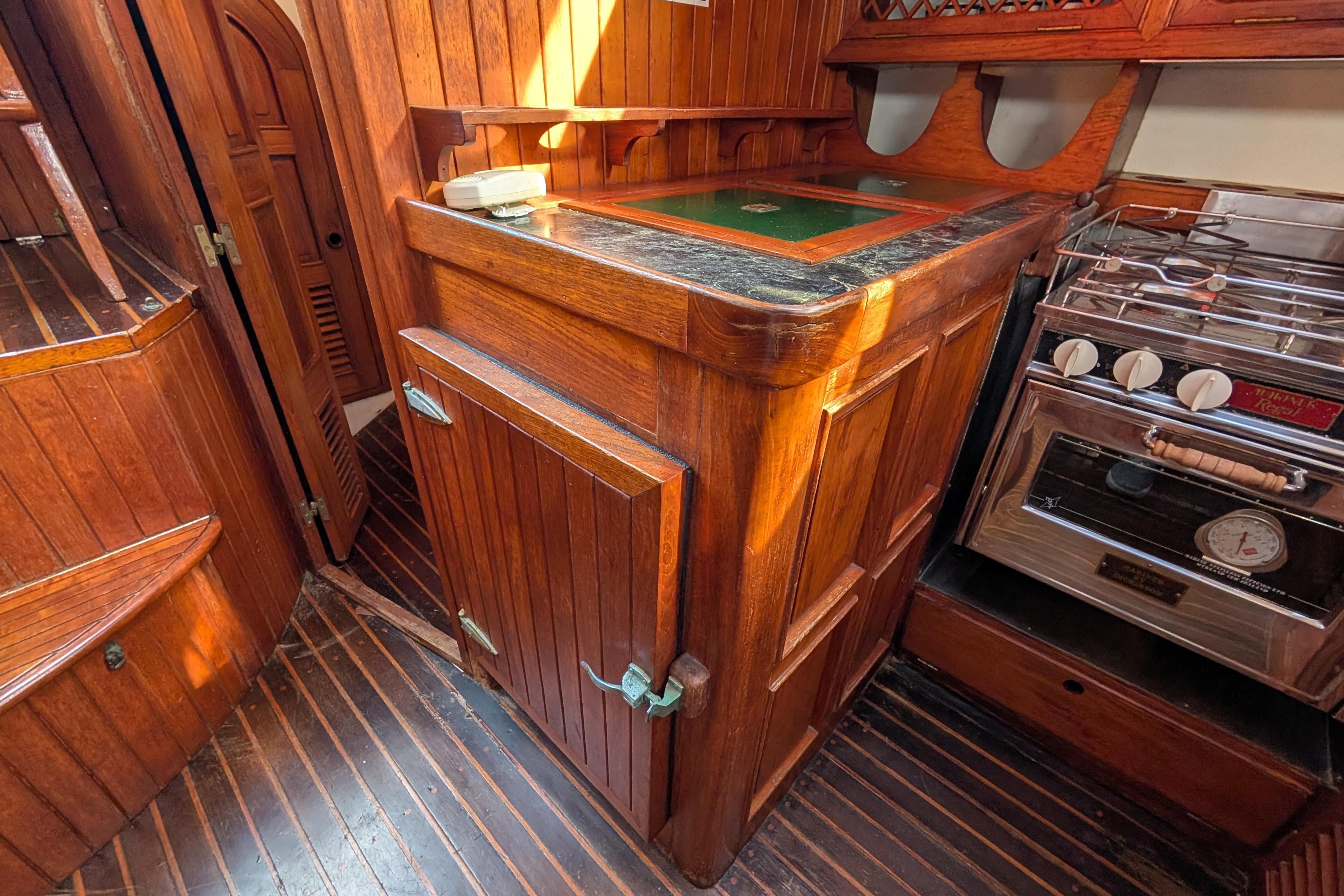 Wooden interior of 1983 Robert Perry 41 yacht with stove and cabinetry.