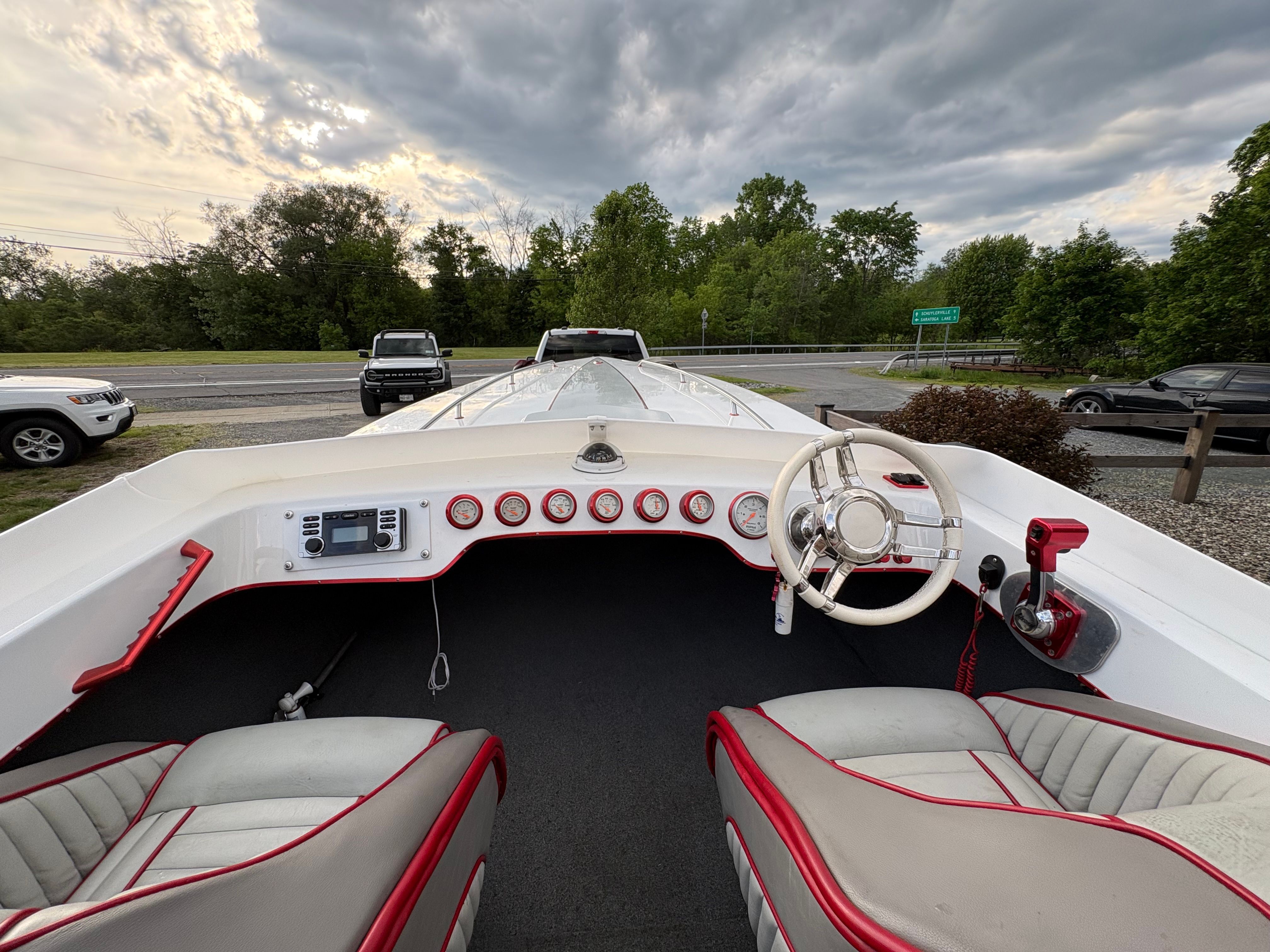 The image shows the cockpit of a 1986 Warlock 23 boat with two seats and a steering wheel.