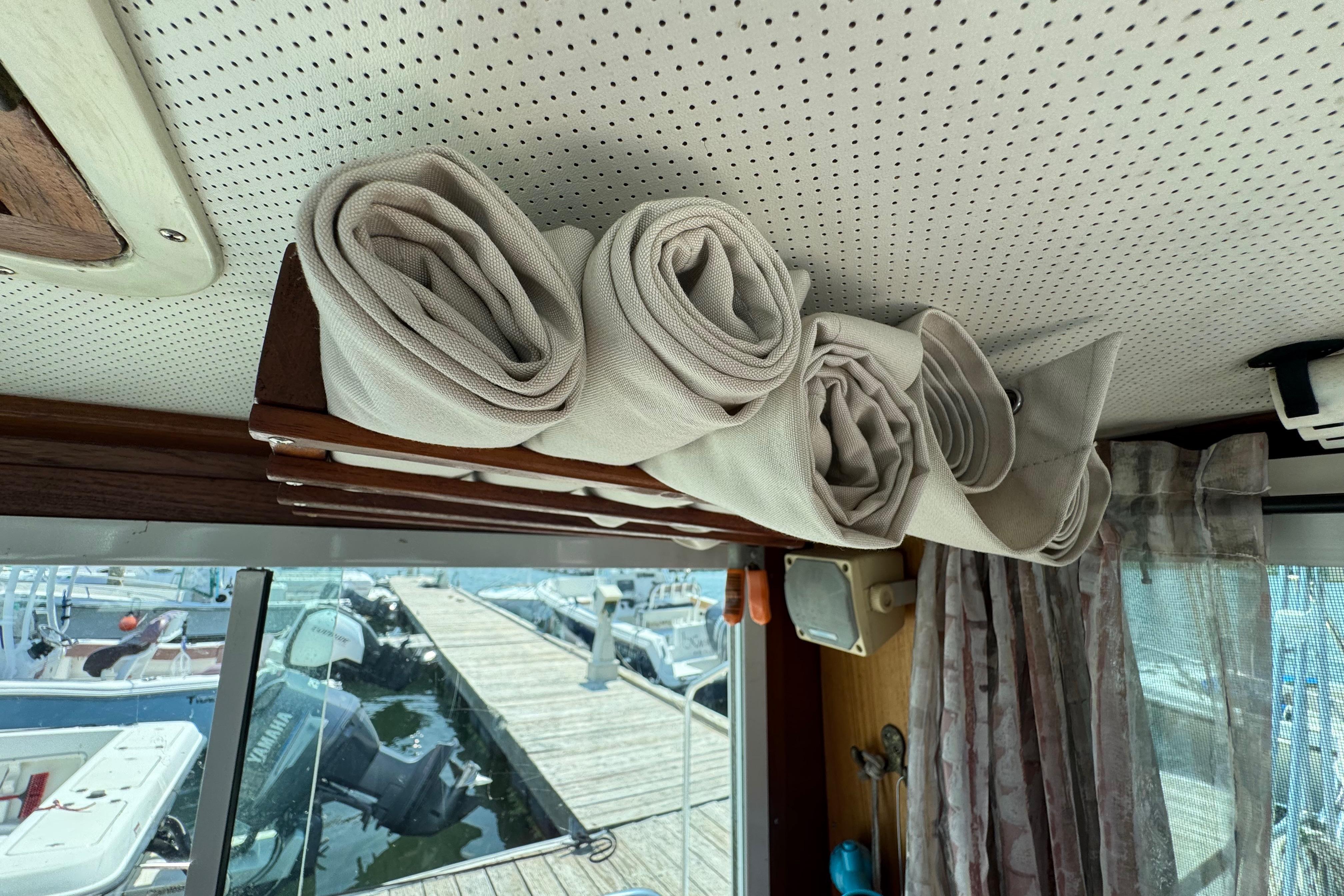 Interior of 1989 Cape Dory 30 Motorsailer with rolled canvas storage above window.