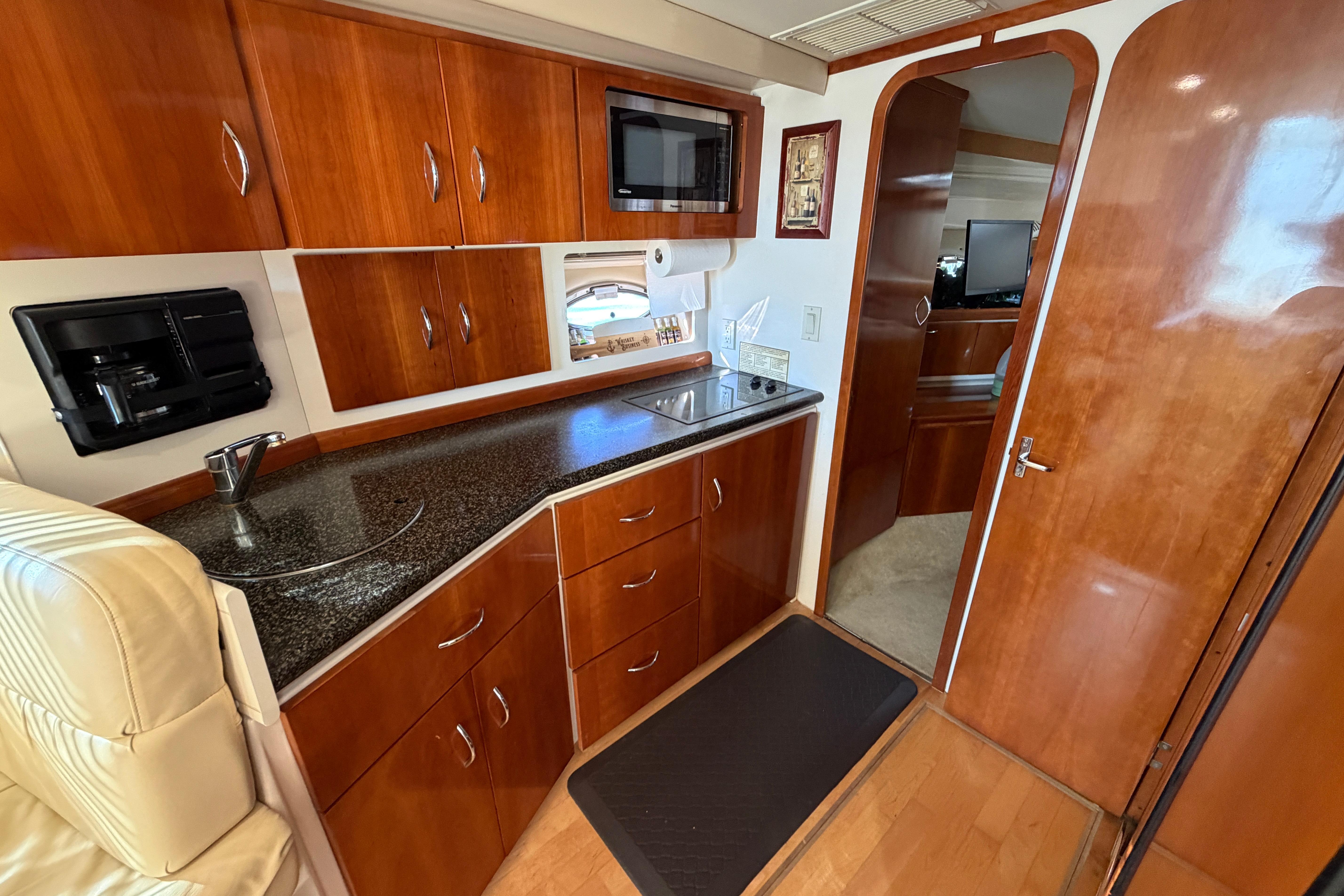 2003 Carver 350 Mariner interior with wood cabinetry, kitchenette, and modern appliances.